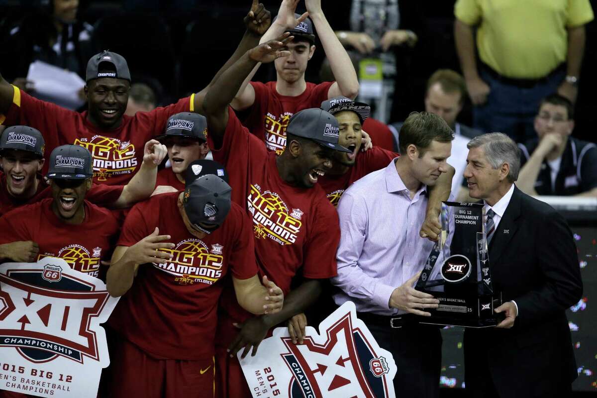 Big 12 commissioner Bob Bowlsby, right, presents the championship trophy to Iowa State head coach Fred Hoiberg following an NCAA college basketball game against Kansas in the finals of the Big 12 Conference tournament in Kansas City, Mo., Saturday, March 14, 2015. Iowa State defeated Kansas 70-66. (AP Photo/Orlin Wagner)