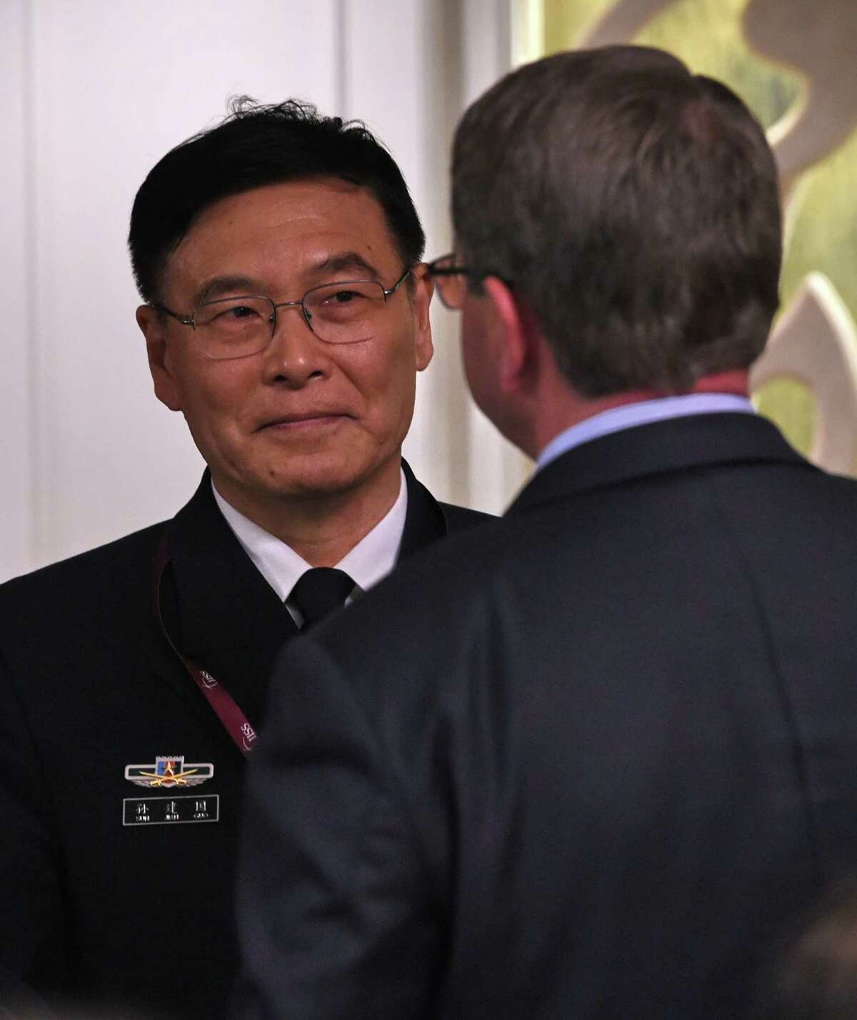 Sun Jianguo (L) from the Chinese People's Liberation Army Navy, chats with US Secretary of Defense Ashton Carter (face back) during the ministerial luncheon at the 14th Asia Security Summit, the International Institute for Strategic Studies (IISS) Shangri-La Dialogue 2015 in Singapore on May 30, 2015. The United States on May 30 called for an "immediate and lasting halt" to reclamation works in disputed waters in the South China Sea, saying Beijing's behaviour in the area was "out of step" with international norms. AFP PHOTO / ROSLAN RAHMANROSLAN RAHMAN/AFP/Getty Images