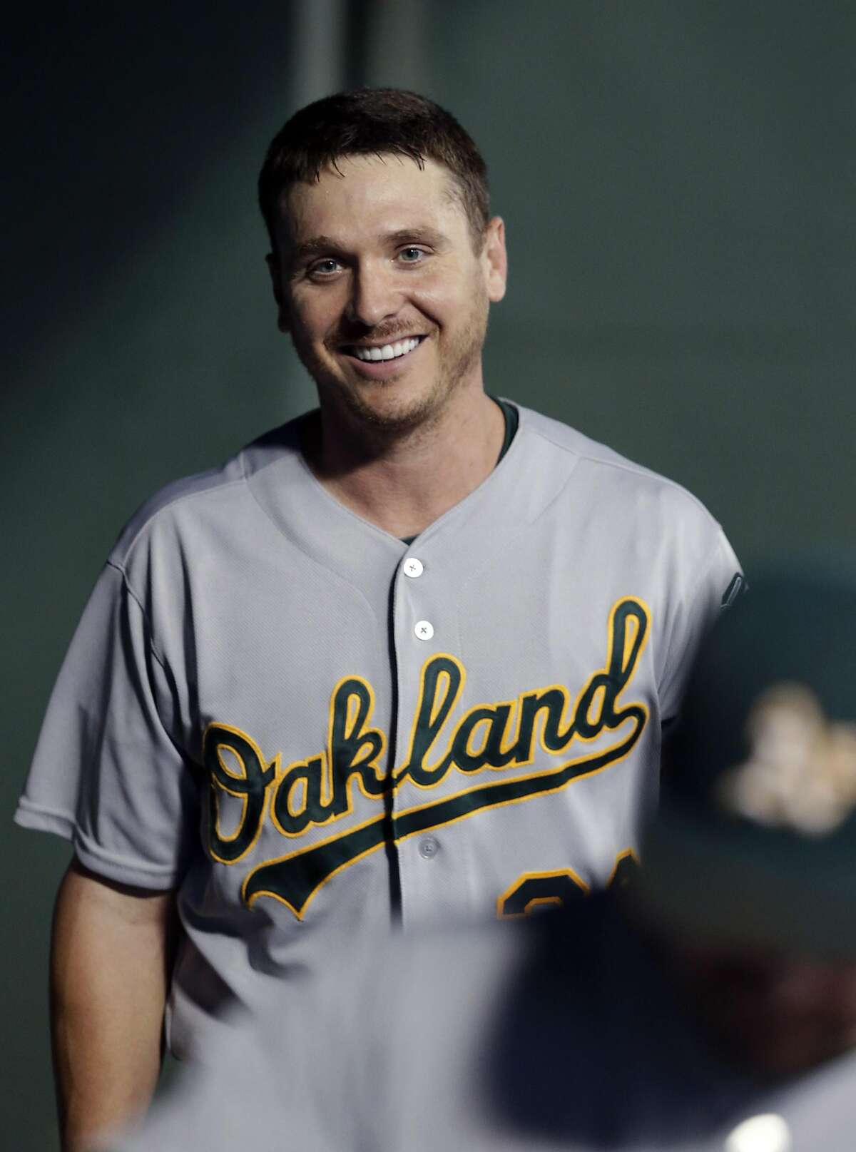 Oakland Athletics starting pitcher Scott Kazmir smiles as he walks in the dugout after coming out of the baseball game against the Texas Rangers in Arlington, Texas, Friday, Sept. 26, 2014. Kazmir won for the first time in seven starts and the Athletics moved ever so close to their third consecutive playoff appearance with a 6-2 victory over the Rangers. (AP Photo/LM Otero)