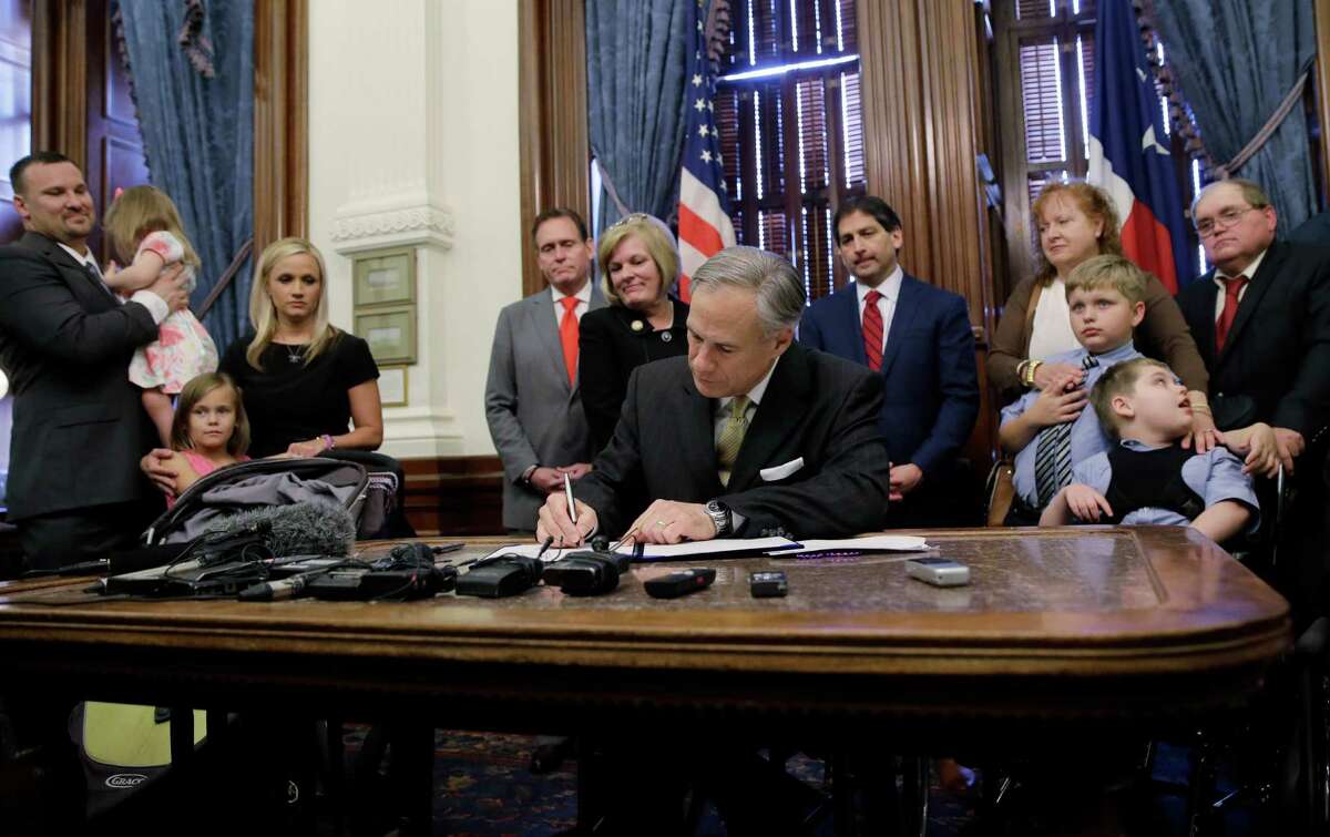 Texas Gov. Greg Abbott, front center, signs SB 339, a bill allowing the medical use of low-THC cannabis, into law at the Texas Capitol, Monday, June 1, 2015, in Austin, Texas. (AP Photo/Eric Gay)