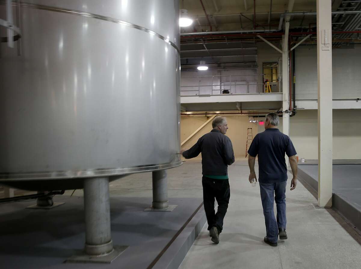 主人肖恩·奥沙利文(左)和尼克Freccia走过的一个巨大的酿造坦克周一6月1日,2015年。21修正案酿酒厂是打开一个巨大的和雄心勃勃的在圣莱安德罗数百万美元的设施,加州的网站前凯洛格麦片厂。