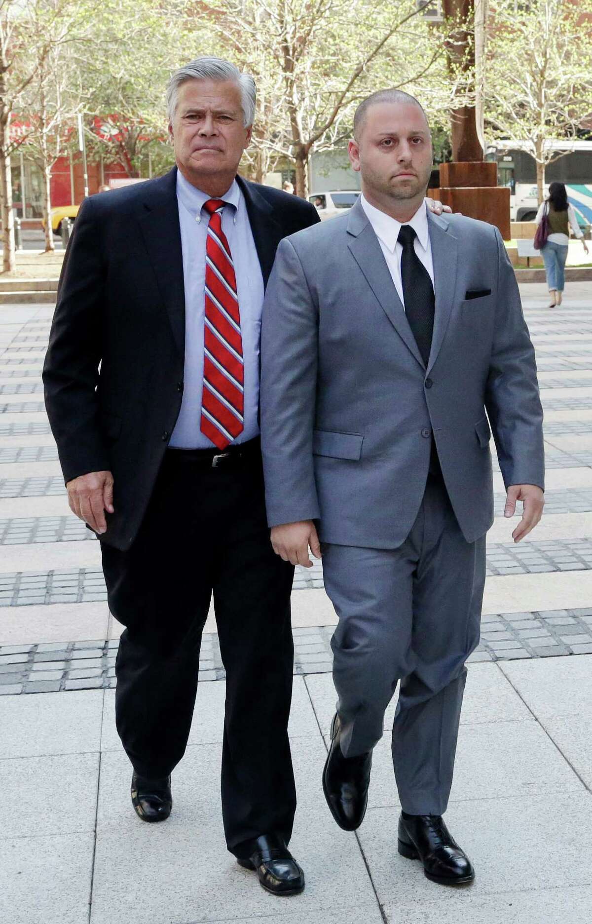 FILE- In this May 4, 2015 file photo, New York Senate Majority Leader Dean Skelos, left, and his son Adam arrive at FBI offices in New York. The pair surrendered to face charges including extortion and soliciting bribes amid a federal investigation into the awarding of a $12 million contract to a company that hired his son. In spite of the charges against him, people on Long Island are using words like "pillar of the community," and a "good guy" to describe the embattled New York Senate leader. (AP Photo/Mark Lennihan, File)