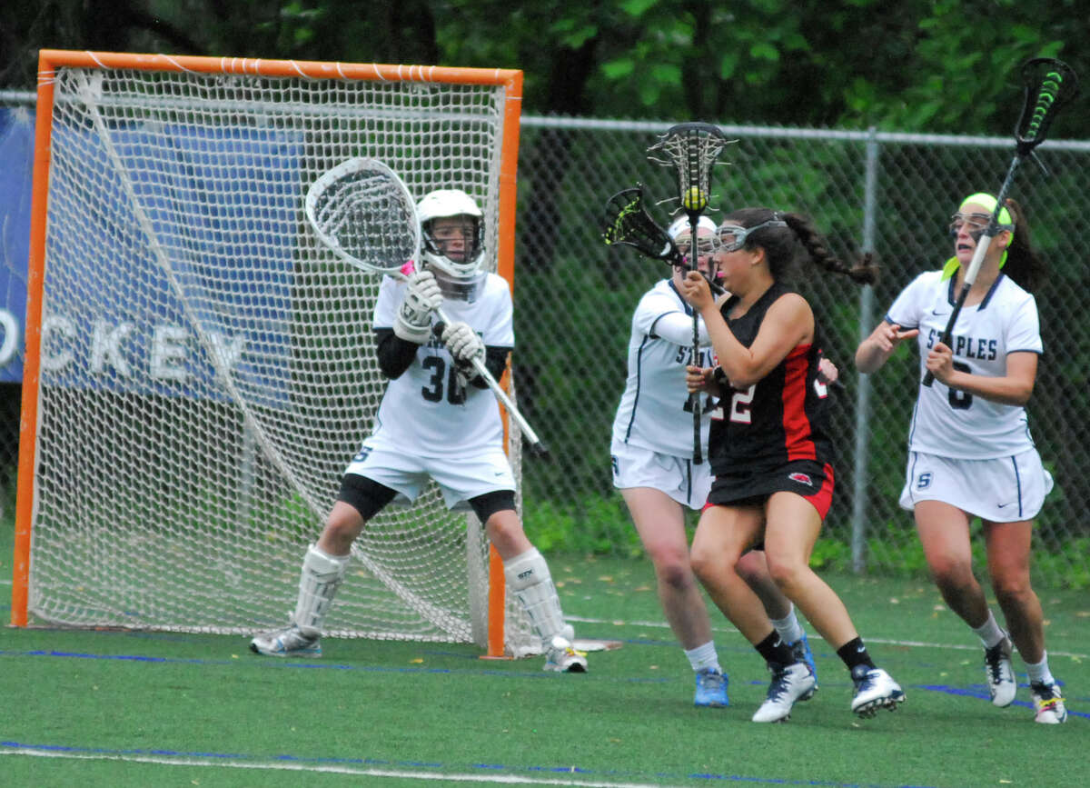 Fairfield Warde's Clare Secrist, second from right, tries to fight through the Staples defense while goalie Emma Boland, left, looks on during a Class L girls lacrosse game on Monday, June 1 2015 in Westport, Connecticut. Staples won 11-8.
