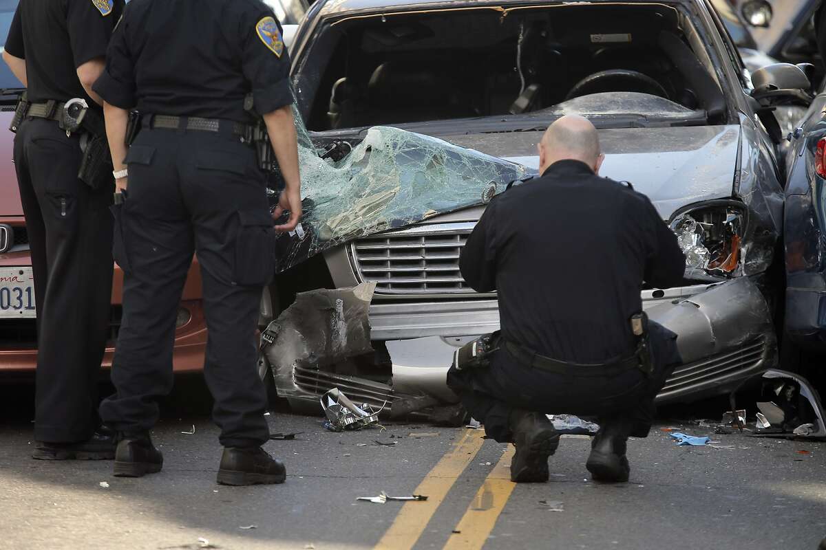 SFPD officers gather evidence at the scene of a car crash after a wanted parolee led officers on a chase from the Bayview district to Market Street and Fifth Street where he crashed his car into several vehicles before being stopped and apprehended in San Francisco, Calif., on Monday, June 1, 2015. There were two minor injuries from the accident and both were transported to the hospital.