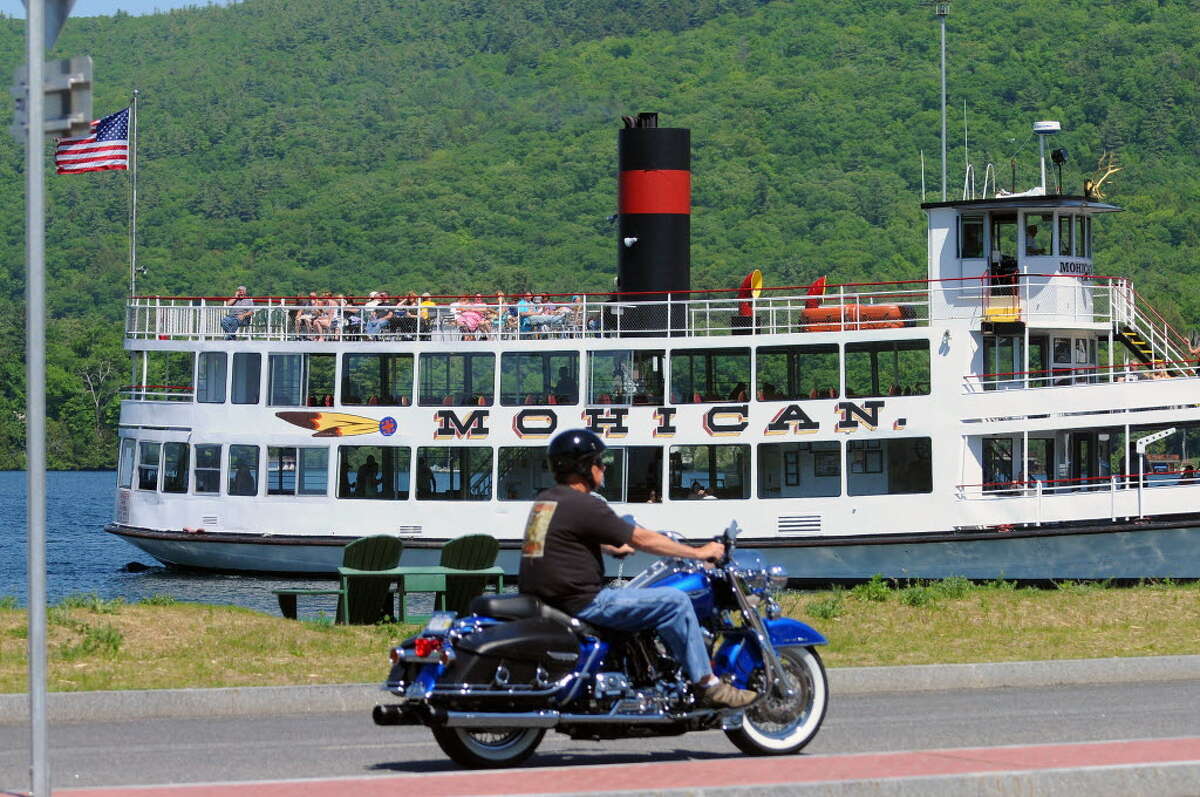 The tour boat Mohican heads out into Lake George as an Americade rider goes by on Monday, June 2, 2014, in Lake George, N.Y.