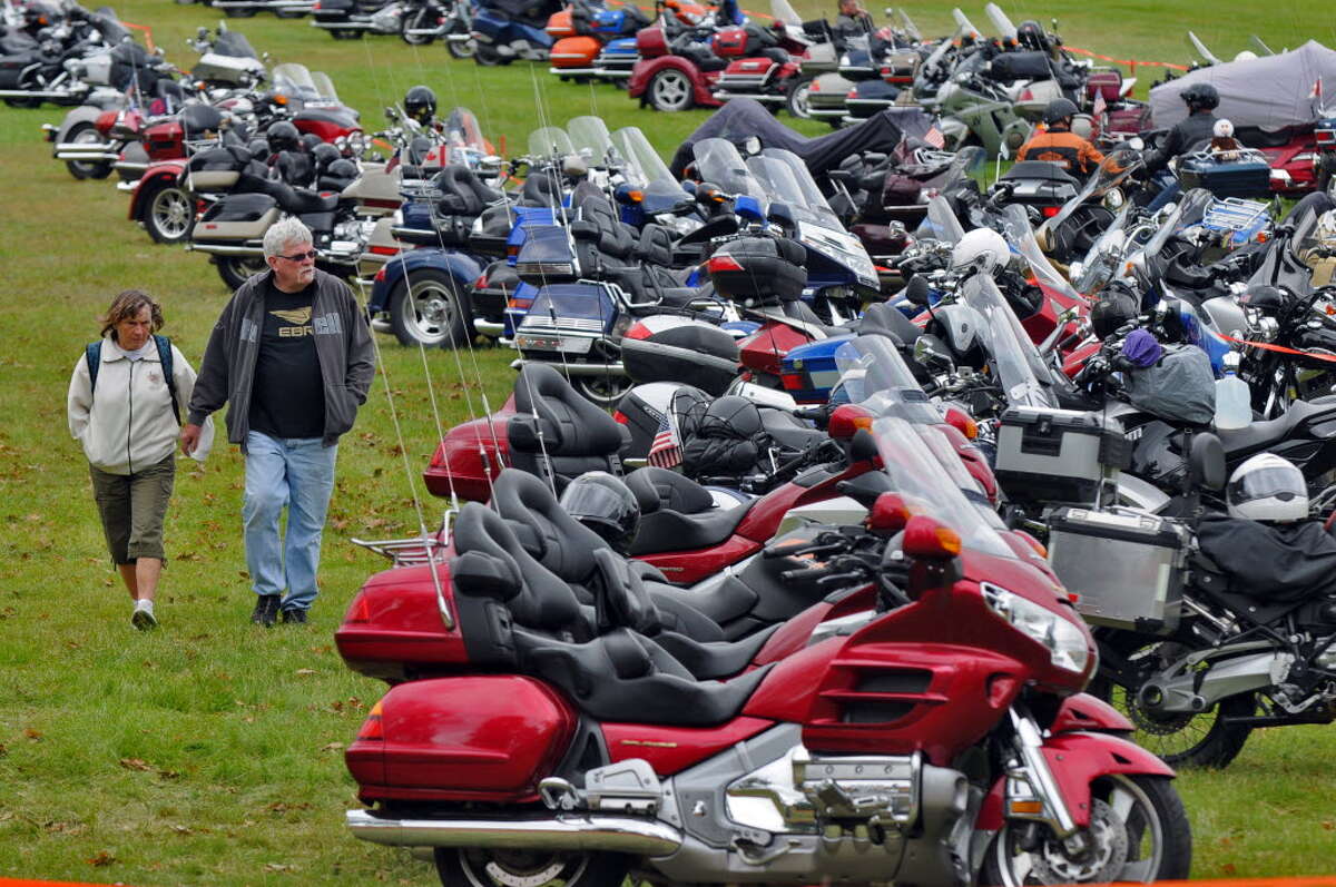 Bobbi and David Reeves of Peru, NY walk past motorcycles parked in Lake George Battlefield State Park for the start of the annual Americade, on Tuesday June 5, 2012 in Lake George, NY. The parking donations for the parking lot were to benefit the Prospect Child and Family Center, of Queensbury. 