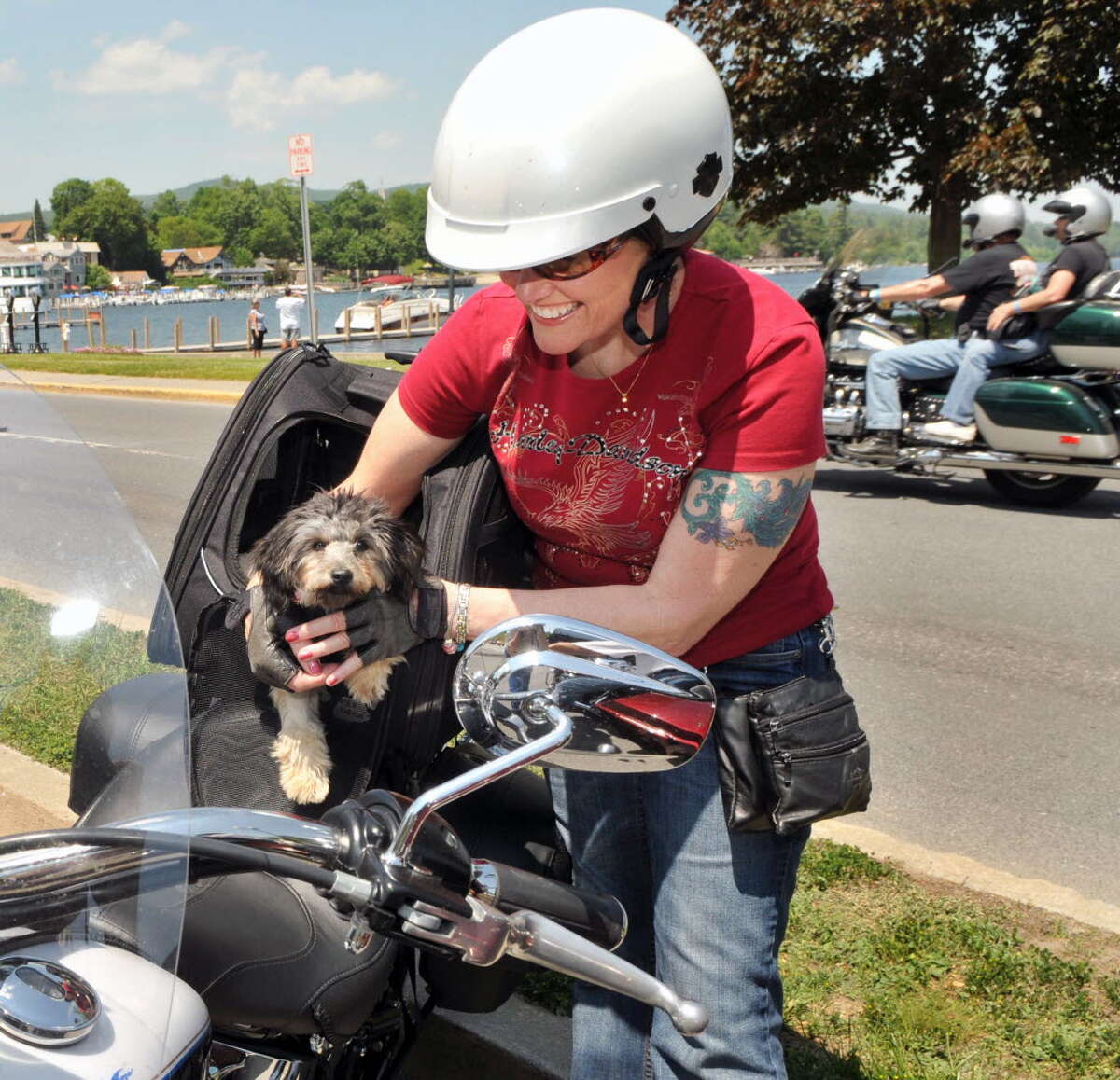 Motorcyclist Michelle Gonsalves of South Paris, Maine fill tucks her 6-month-old puppy 