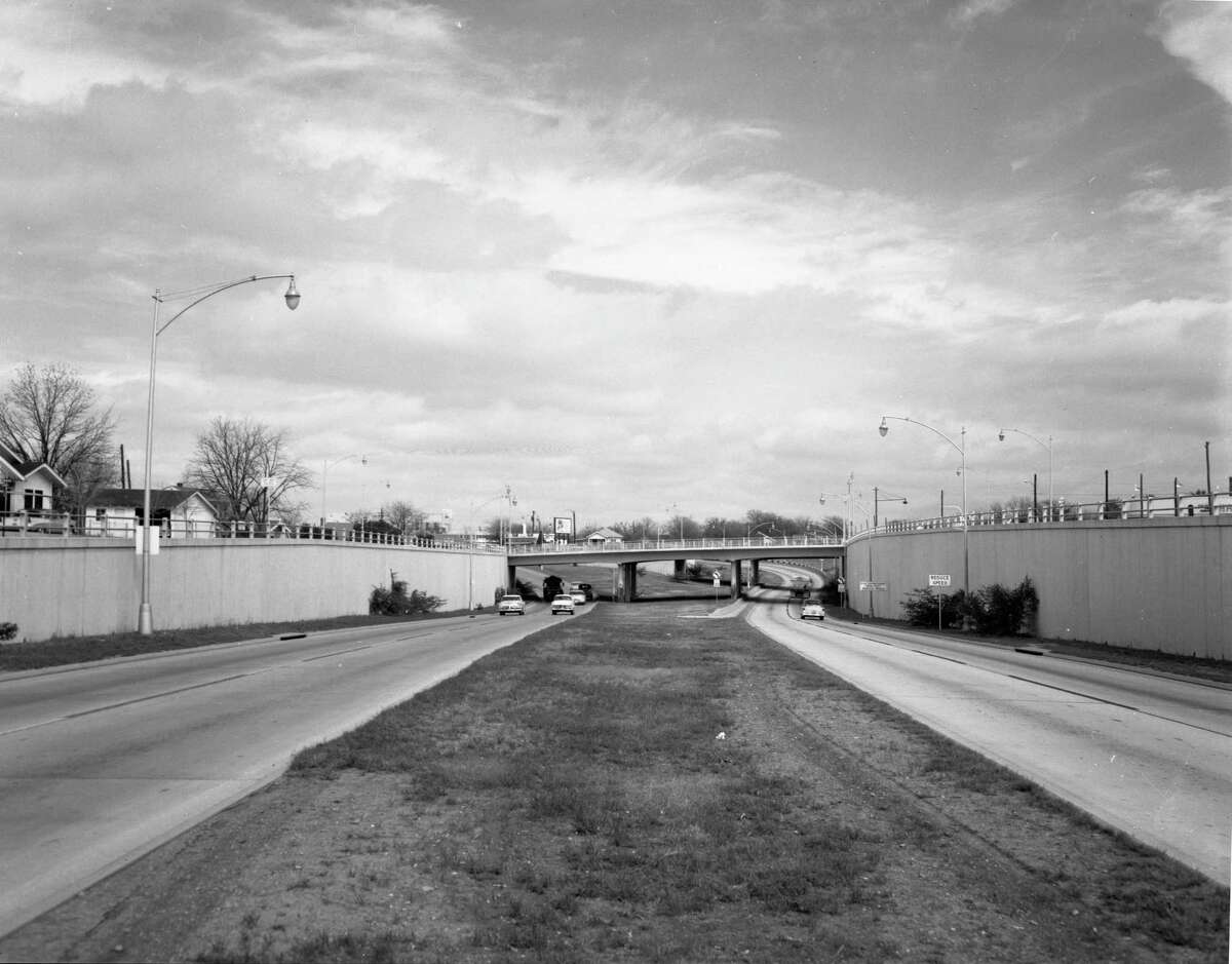 The San Antonio Expressway is shown in this circa 1950s photo. It is on I-10 northwest of downtown. The overpass is Woodlawn Avenue, and just beyond that is Fredericksburg Road. This photo was taken sometime in the 1950s when the roadway was US 87. The freeway ended there at Fredericksburg Road, and in the background, you can see where it curves to the left to merge onto Fredericksburg. This was the first section of freeway in San Antonio.