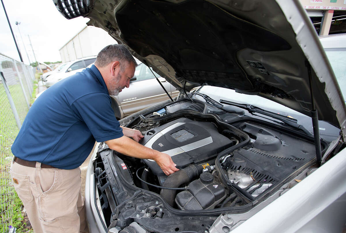 Rick Kimminau with Farmers Insurance, examines vehicles damaged by floods at a vehicle repair shop in the 8800 block of W. Sam Houston Parkway South, Friday, May 29, 2015, in Houston. Flooded cars are being towed to lots where insurance adjusters look at them to see if they're totaled or can be repaired. (Cody Duty / Houston Chronicle)