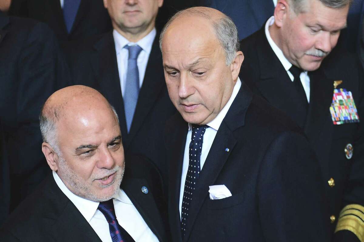 Iraqi Prime Minister Haider al-Abadi, left, and French Foreign Affairs Minister Laurent Fabius arrive to pose for a group photo with Foreign Affairs ministers and members of the anti-Islamic State coalition after a meeting in Paris, France, to discuss strategy in fighting the jihadist militant group, who have made key battlefield advances in recent weeks in Iraq and Syria, Tuesday, June 2, 2015. Iraqâs prime minister and international allies are gathering in Paris to re-examine their strategy against Islamic State extremists, after the groupâs recent gains. The coalition, which includes the United States and France but not Russia, Iran or Syria, is meeting Tuesday after extremists conquered both the Iraqi city of Ramadi and the historic Syrian city of Palmyra. (Stephane de Sakutin/Pool Photo via AP)