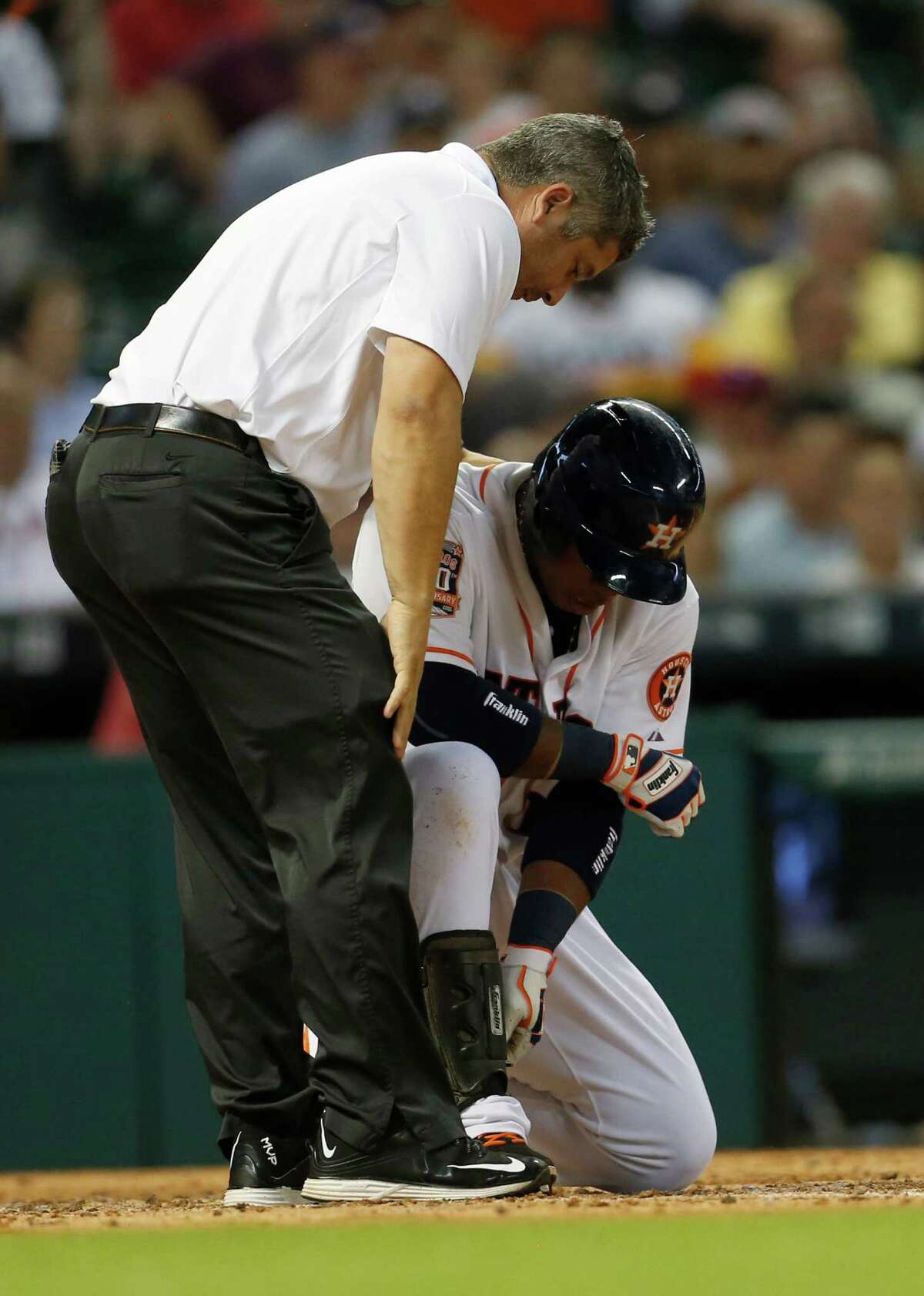 Astros third baseman Luis Valbuena was dishing out and taking punishment Tuesday night. He homered in the third, needed attention from trainer Nate Lucero, left, after being hit by a pitch in the fifth, and let loose after scoring an insurance run in the eighth, right.