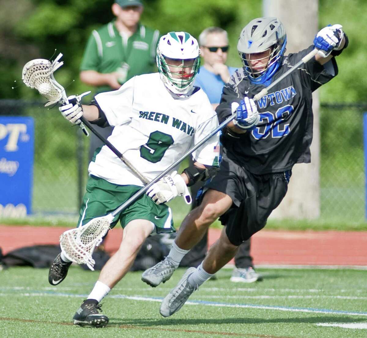 New Milford High School's Justin Lourenco is stick checked by Newtown High School's Nicholas Rubino in the boys lacrosse Class L first round game played at Brookfield High School. Wednesday, June, 3, 2015