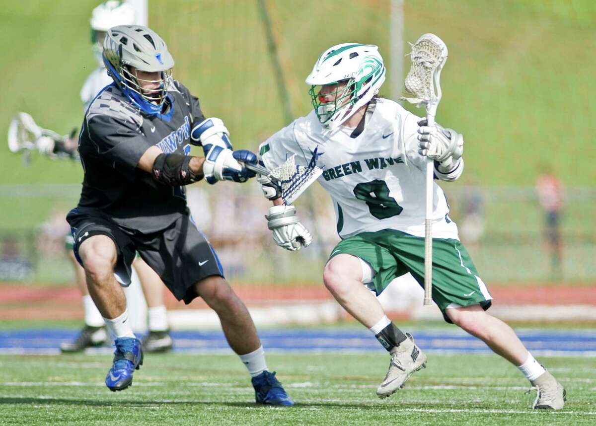Newtown High School's Bobby Lydon pokes at New Milford High School's Blaine McMahon in the boys lacrosse Class L first round game played at Brookfield High School. Wednesday, June, 3, 2015