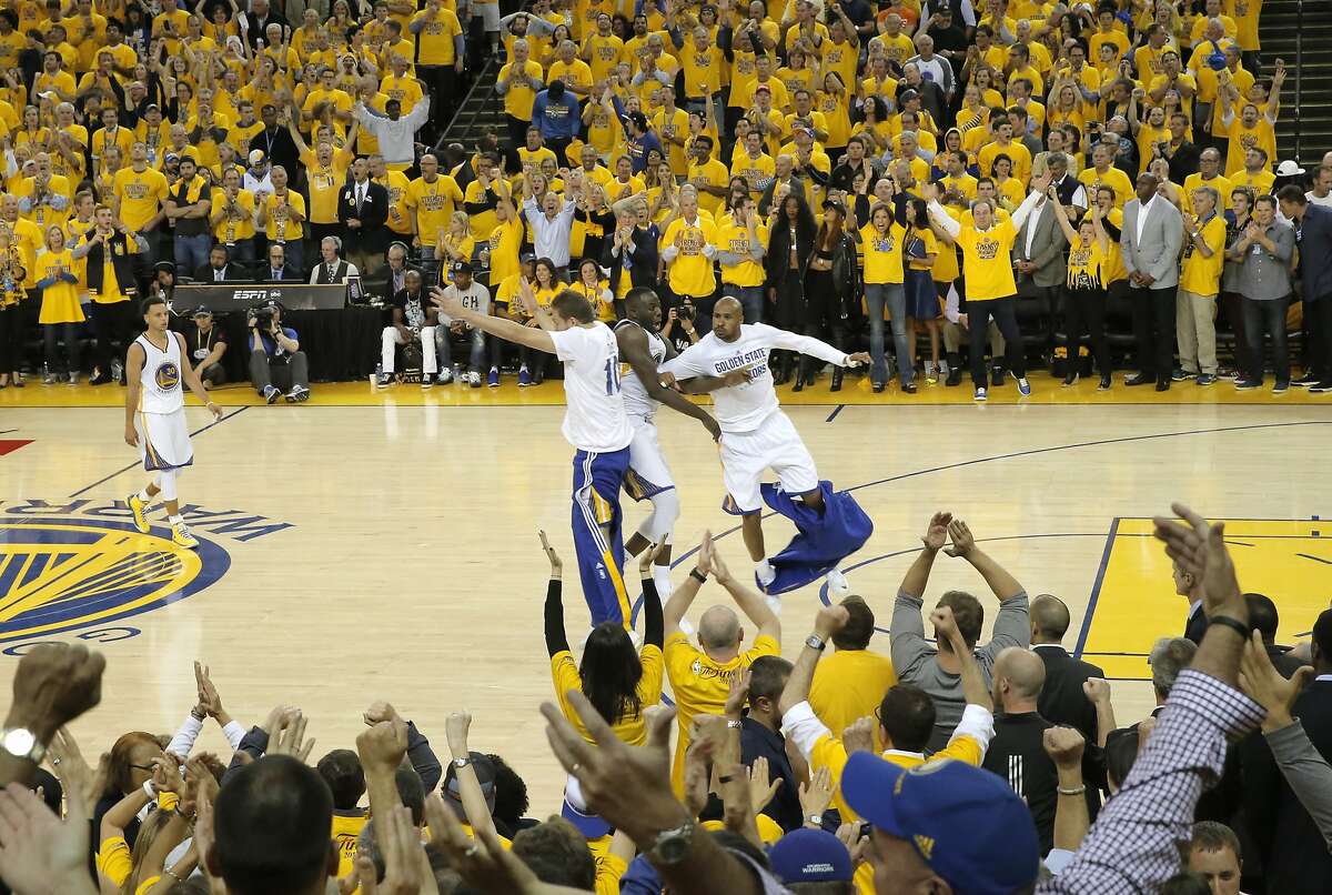 (l to r) David Lee, Draymond Green and Leandro Barbosa jump in celebration late in overtime as the Golden State Warriors went on to beat the Cleveland Cavaliers 108-100 in Game one of the NBA finals at Oracle Arena, in Oakland, Calif., on Thurs. June 4, 2015.