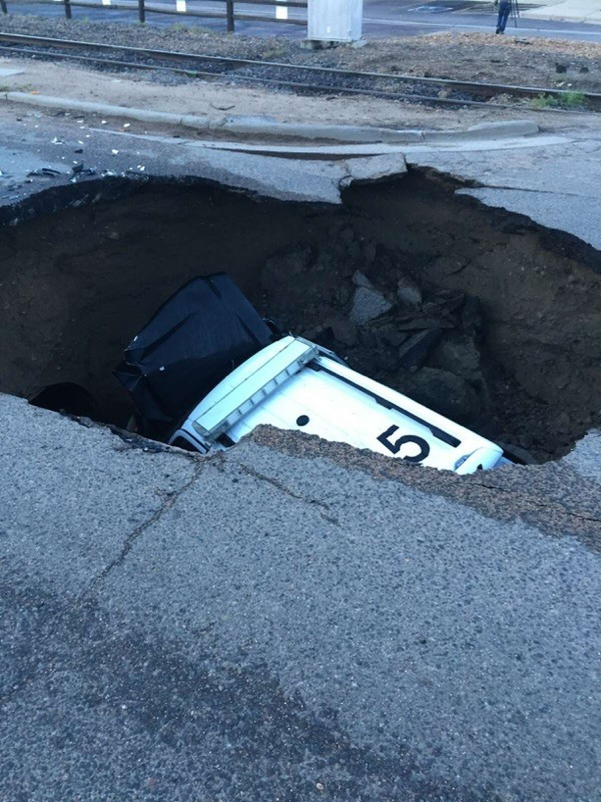 A police SUV was swallowed by a 15-feet deep sinkhole Friday morning near Denver following torrential storms that hit the area.