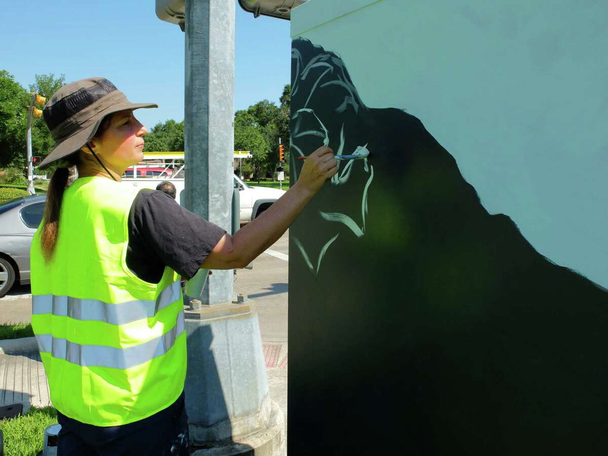 Artist Anat Ronen began painting the 8x4-foot traffic signal control cabinet at the corner of West Bellfort and Willowbend Streets with a morning glory design Thursday morning. By the day's end she had finished the first of 31 planned "mini murals" by street artists in a new program organized by UP Art Studio and supported by various municipal programs and organizations.