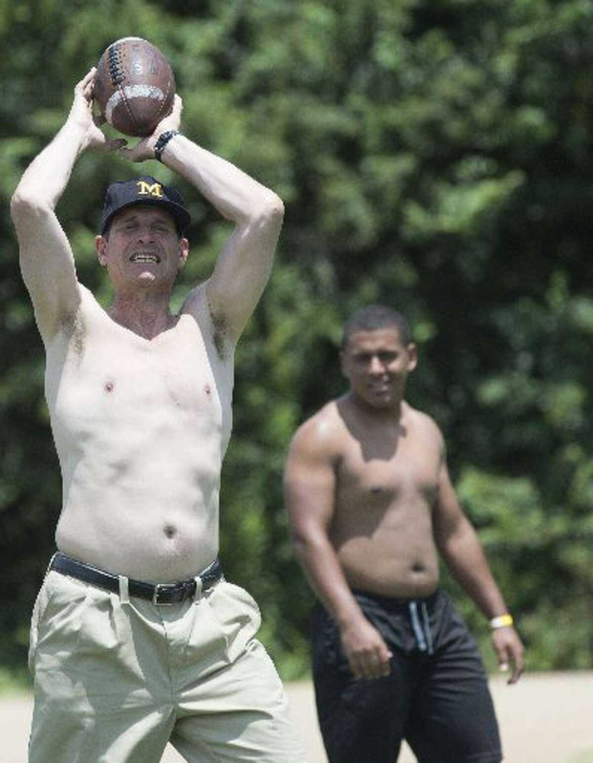 Michigan football coach Jim Harbaugh plays shirtless with participants during the Coach Jim Harbaugh's Elite Summer Football Camp, Friday, June 5, 2015, at Prattville High School in Prattville, Ala.