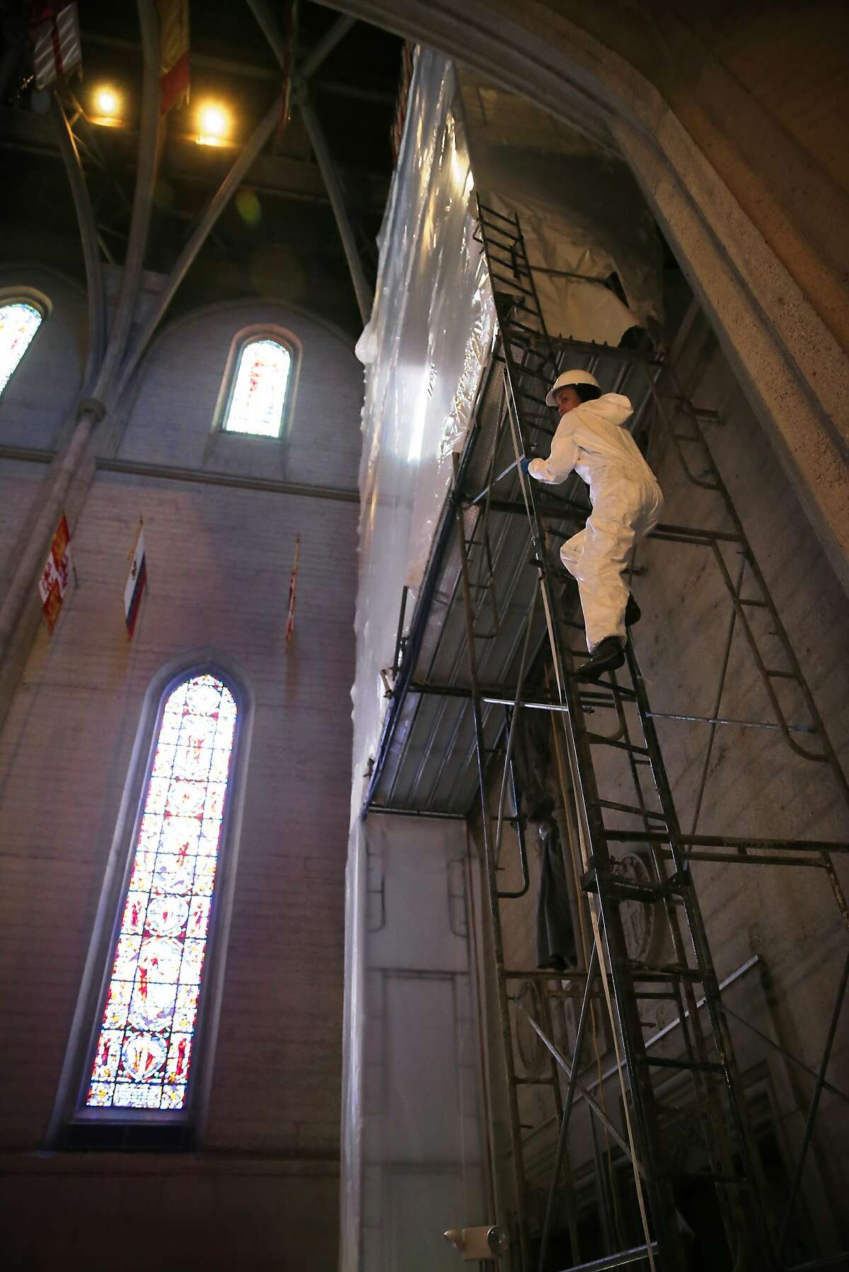 Ariana Makau, owner&principal conservator of Nzilani glass conservation climbs the scaffolding fifty feet off the ground that encases the 5,000 pieces of stained glass at Grace Cathedral in San Francisco, Calif., as seen on Fri. June 5, 2015.