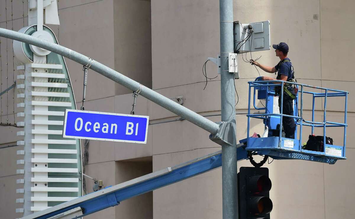 A worker fixes the wiring above traffic lights in Long Beach, California. The U.S. economy pumped out 280,000 jobs in May, the Labor Department announced, far more than expected in a solid sign of growth after a winter stall.
