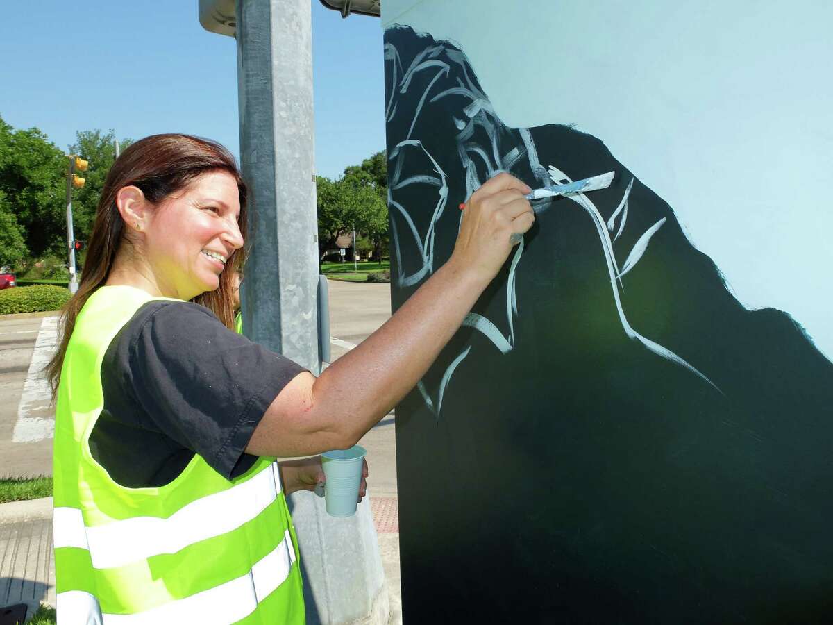 Artist Anat Ronen began painting the 8x4-foot traffic signal control cabinet at the corner of West Bellfort and Willowbend Streets with a morning glory design Thursday morning. By the day's end she had finished the first of 31 planned "mini murals" by street artists in a new program organized by UP Art Studio and supported by various municipal programs and organizations.