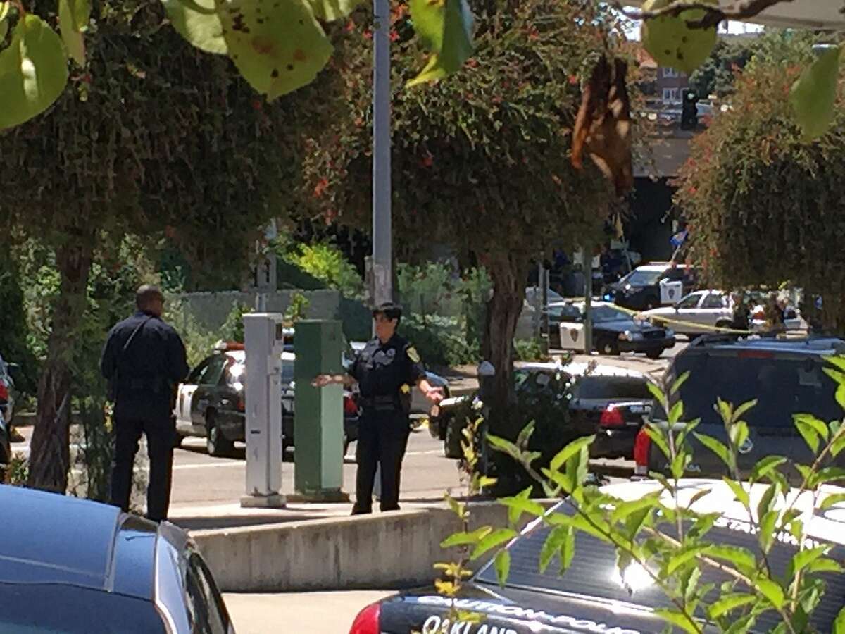 Oakland police examine the scene where an officer shot and killed a man carrying a gun in a BMW at Lake Park and Lakeshore avenues near Lake Merritt.