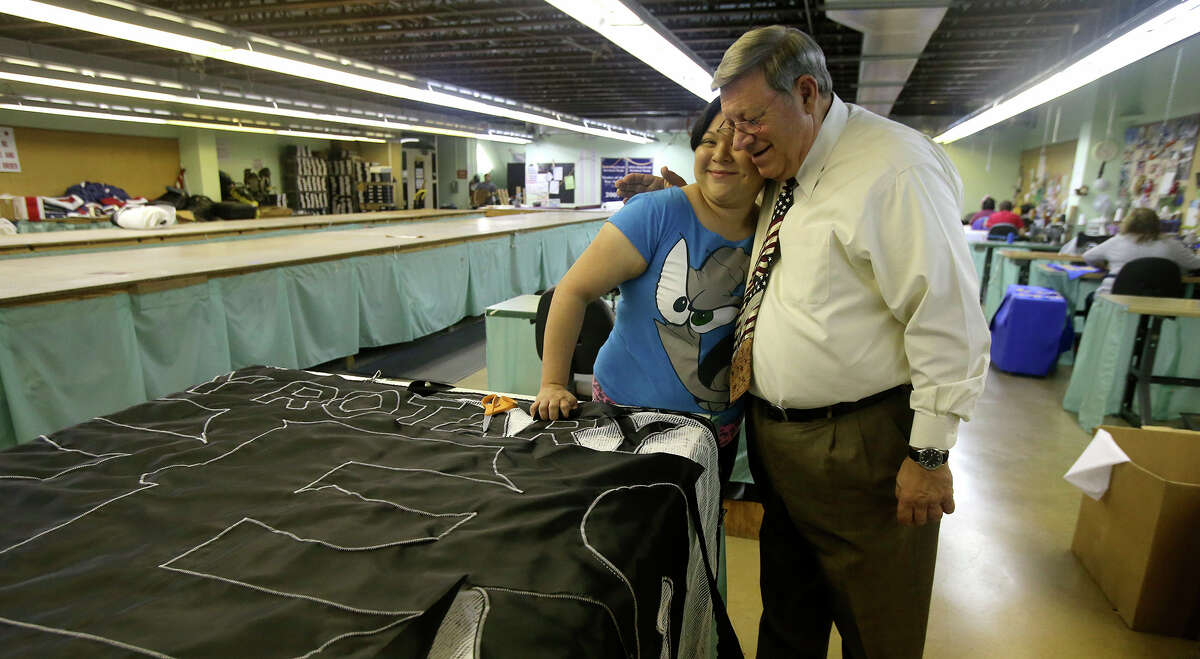 Pete Van de Putte (right) hugs employee Danielle De La Rosa (left) and owns Dixie Flag Manufacturing Company. His parents started the business in 1958 and their first job was for the Poteet Strawberry Festival. His wife, former state senator Leticia Van de Putte, is running for mayor of San Antonio and is facing incumbent Ivy Taylor in a June 13, 2015, runoff election.