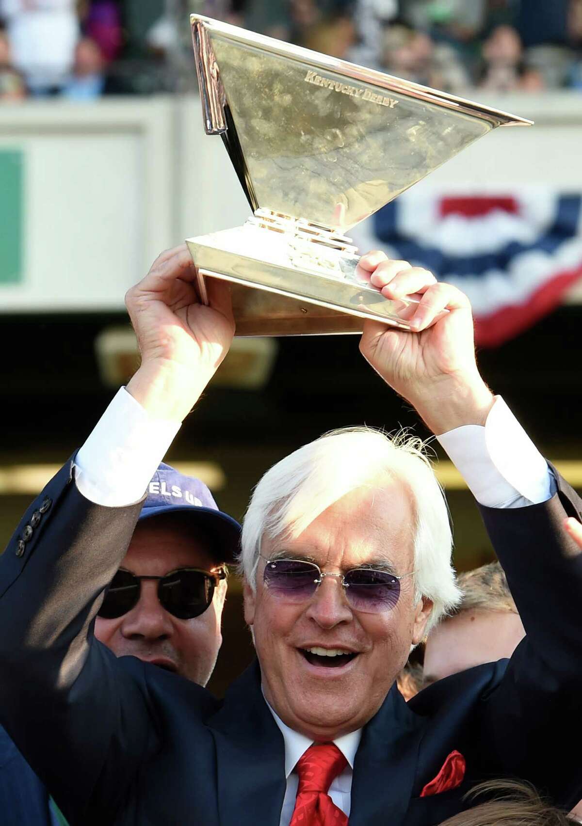 American Pharoah's trainer holds the Triple Crown trophy aloft after his trainee made his way to the record books by winning the 147th running of the Belmont Stakes and thoroughbred racing's Triple Crown June 6, 2015 at Belmont Park in Elmont, N.Y. (Skip Dickstein/Times Union)