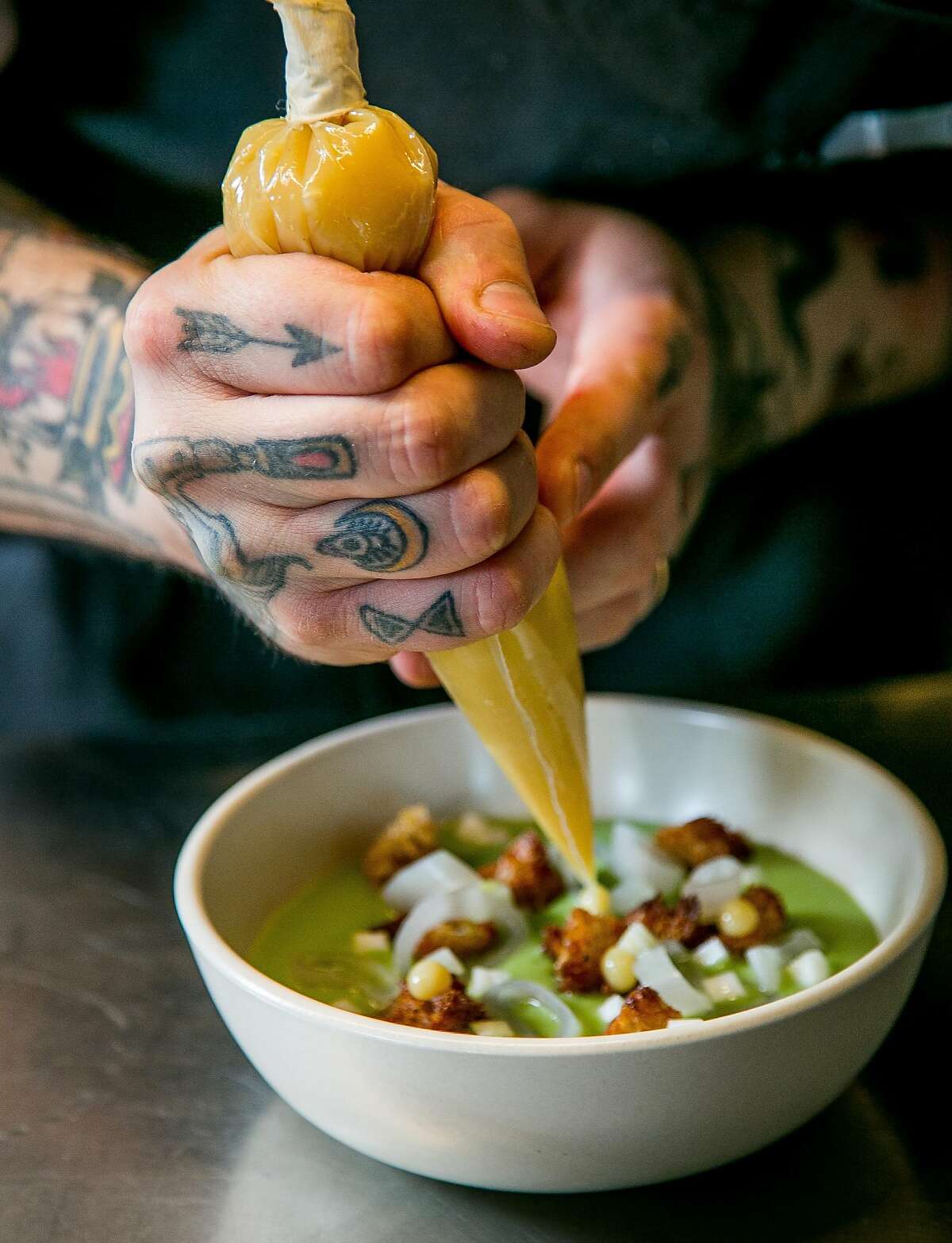 Chef Brett Cooper plates the Green Garlic soup at Aster in San Francisco, Calif., on June 6th, 2015.