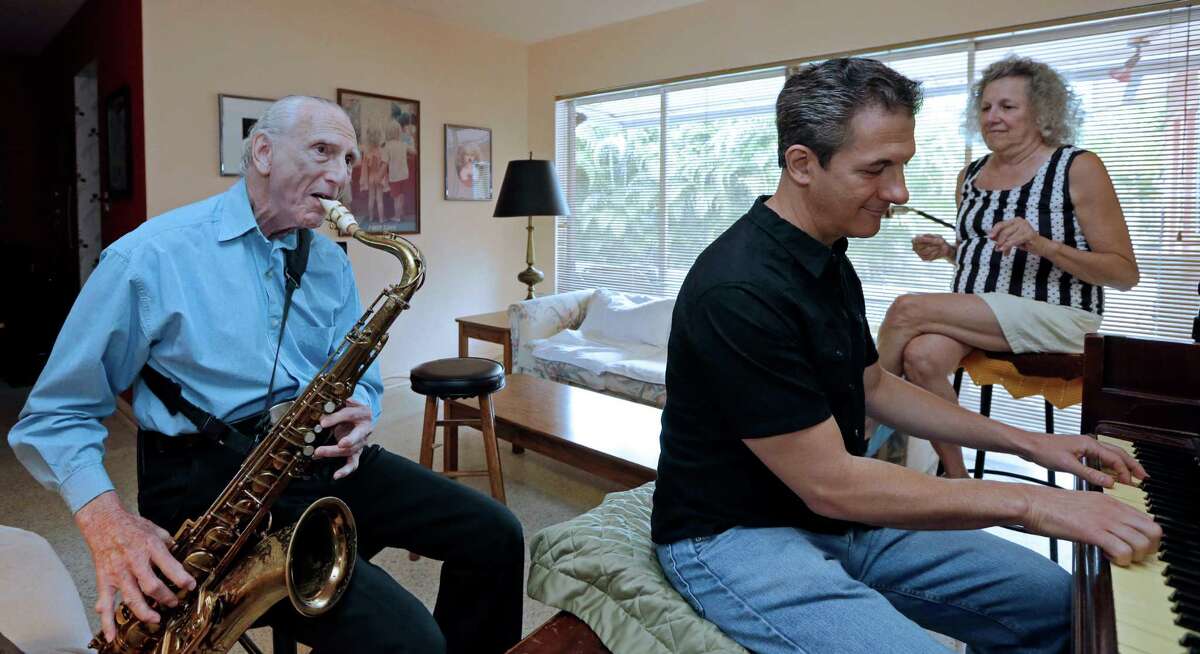Al Karp (left) plays the saxophone as he rehearses with son Larry and wife Saundra at their home in North Miami Beach, Fla. The trio performs old standards as the Karp Family to ease stress and help raise money to save their home from foreclosure.