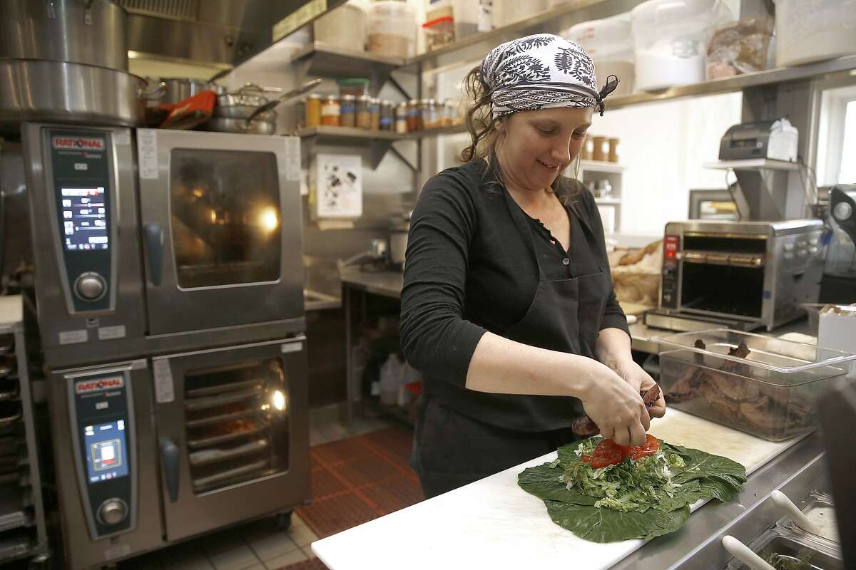 Executive chef Ariel Nadelber makes a collard wrap in the kitchen of Seed and Salt in San Francisco, California, on Tuesday, June 2, 2015.