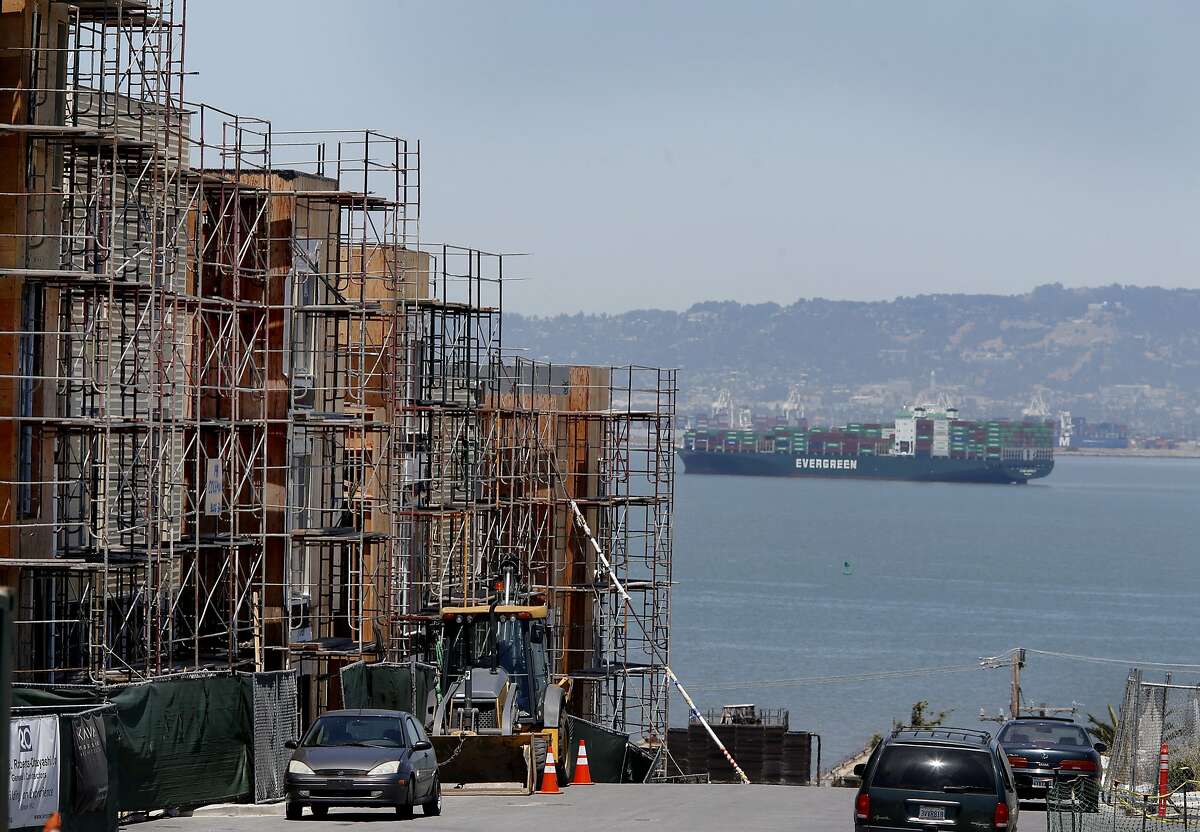 A container ship passes in the bay in the background of the new development Monday June 8, 2015. 88 new housing units are being built and some have moved in to the former Hunters Point Naval Shipyard in San Francisco, Calif. This cleaned up Superfund site is now welcoming the new homeowners.