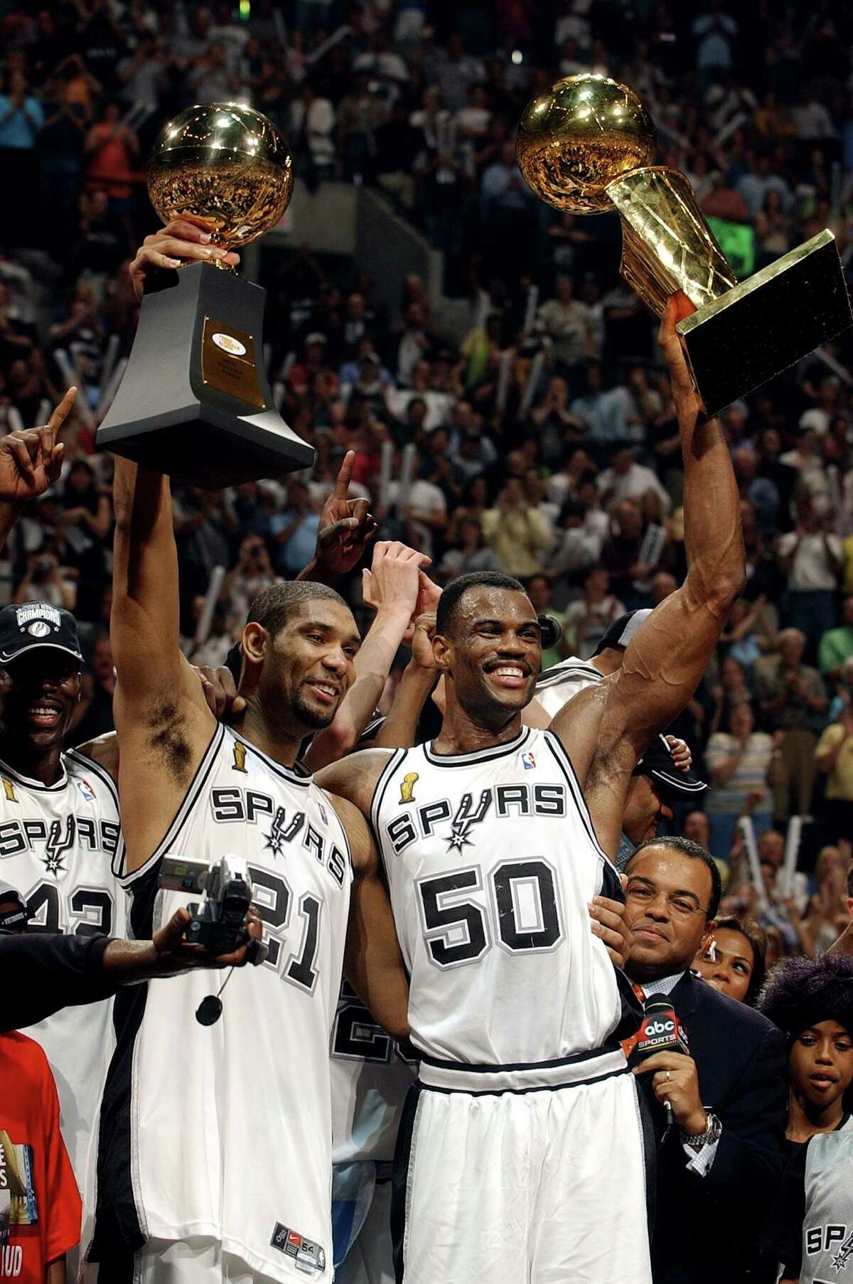 Spurs stars Tim Duncan, with the MVP trophy, and David Robinson, with Larry O’Brien championship trophy, celebrate their NBAcChampionship after Game 6 of the NBA Finals at the SBC Center in San Antonio on June 15, 2003.