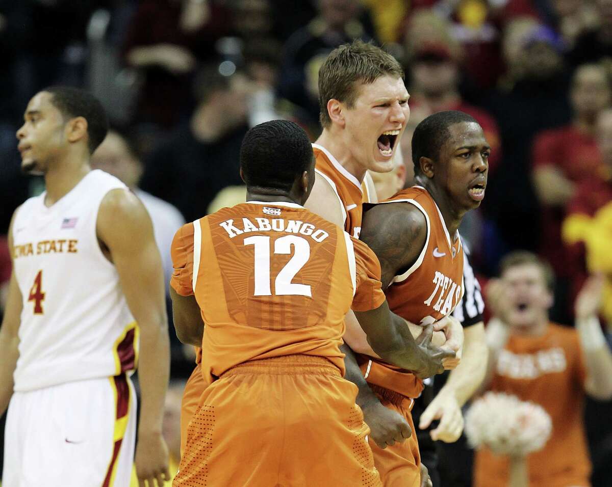 Clint Chapman #53 and Myck Kabongo #12 of the Texas Longhorns celebrate with J'Covan Brown #14 after Brown scored late during the NCAA Big 12 basketball tournament quarterfinal game against the Iowa State Cyclones on March 8, 2012 at Sprint Center in Kansas City, Missouri. (Photo by Jamie Squire/Getty Images)