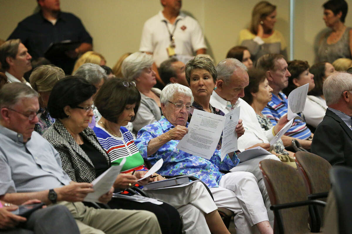 Tina Weir (center) reads fact sheets as she and other residents of the Oakwell Farms neighborhood appear before the Planning Commission to express their objections to a proposed apartment dwelling development within their area on June 10, 2015.