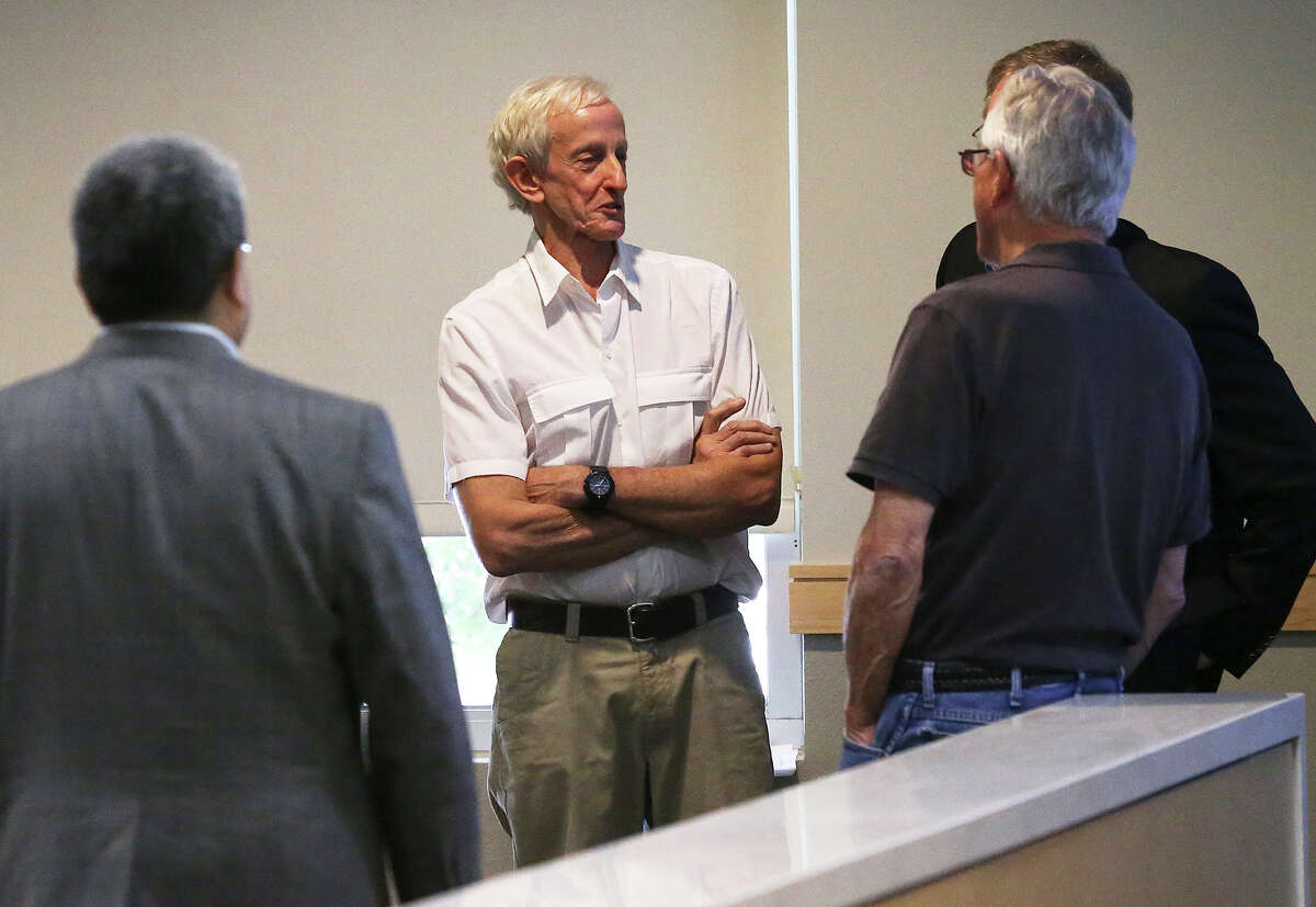 Laddie Denton, an original co-builder with Robert Tobin, chats as residents of the Oakwell Farms neighborhood appear before the Planning Commission to express their objections to a proposed apartment dwelling development within their area on June 10, 2015.