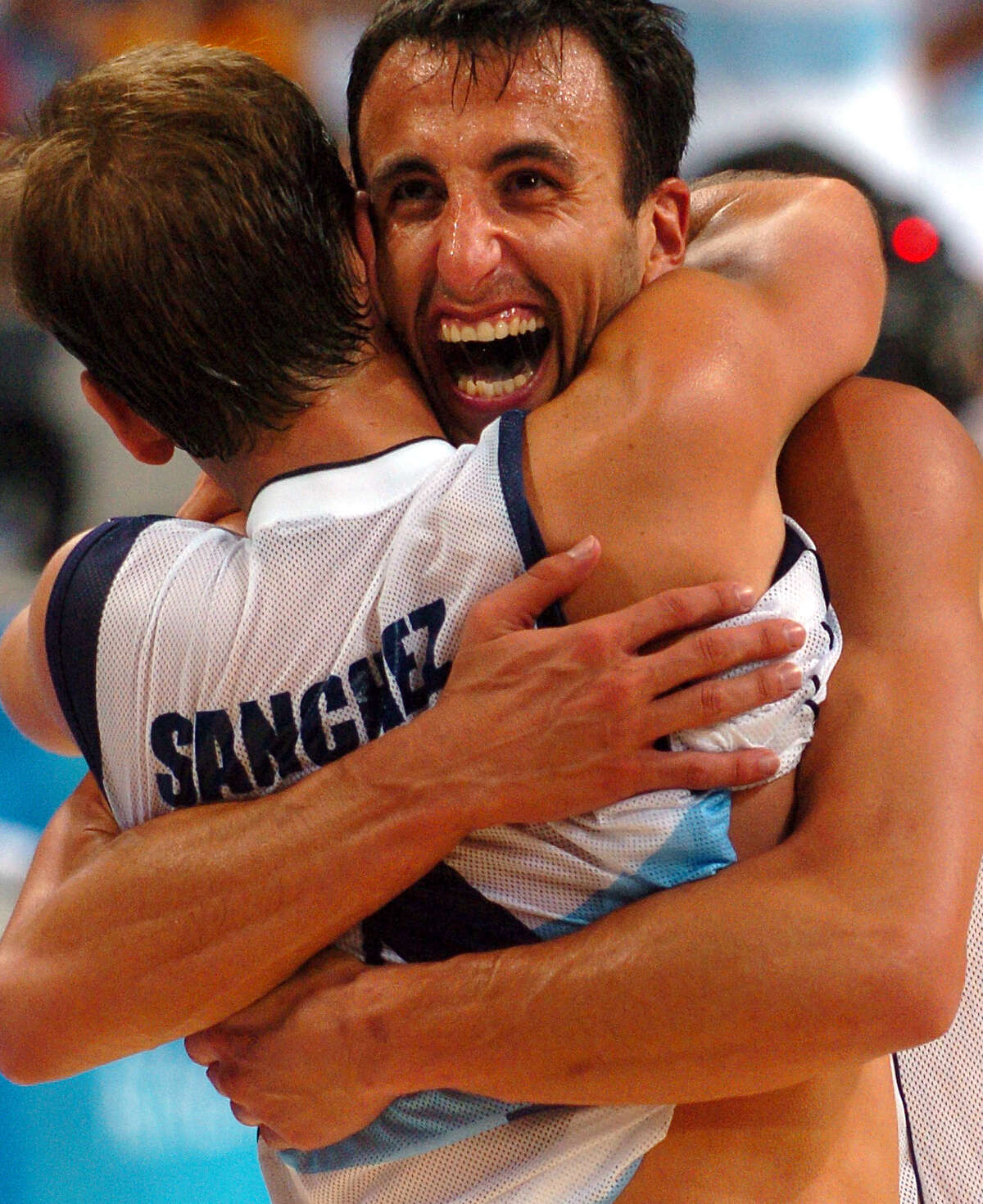 Argentina's Manu Ginobili, facing camera, hugs teammate Juan Ignacio Sanchez Thursday Aug. 26, 2004 in Athens, Greece after Argentina beat the U.S. team 89-81 to advance to the gold medal game during the XXVIII Olympiad. (WILLIAM LUTHER/STAFF)