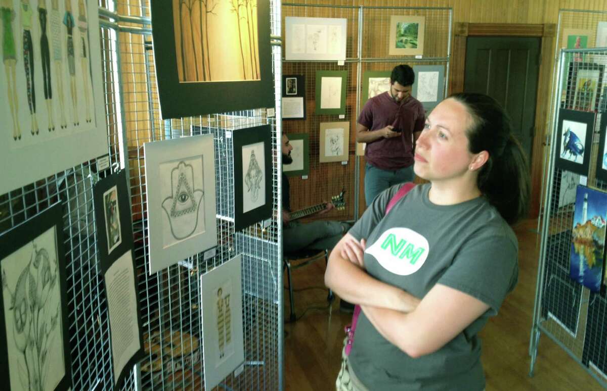 Kristen Stolle, a chemistry teracher at New Milford High School, admires the artwork of Taylor Terranova while patronizing the annual NMHS senior art show at the railroad station.
