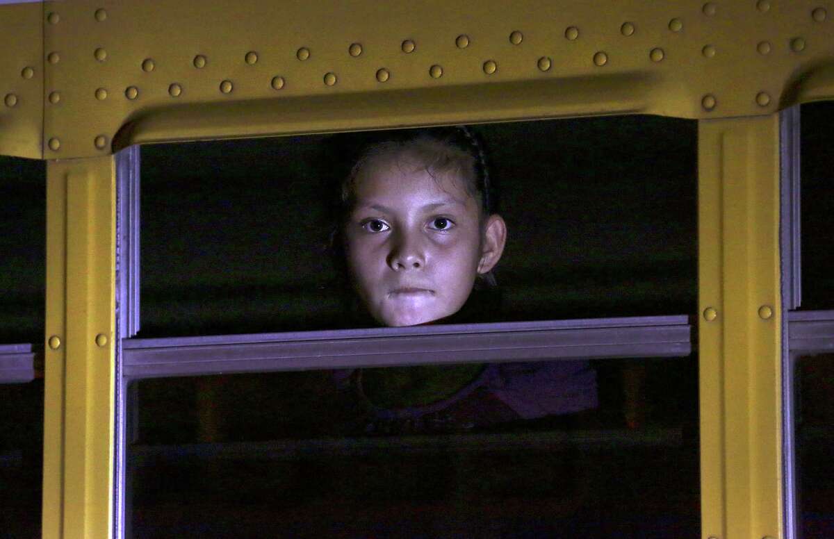 A girl waits on a bus to be taken with other children to a shelter in San Pedro Sula, Honduras, last June. They had been deported from Mexico.