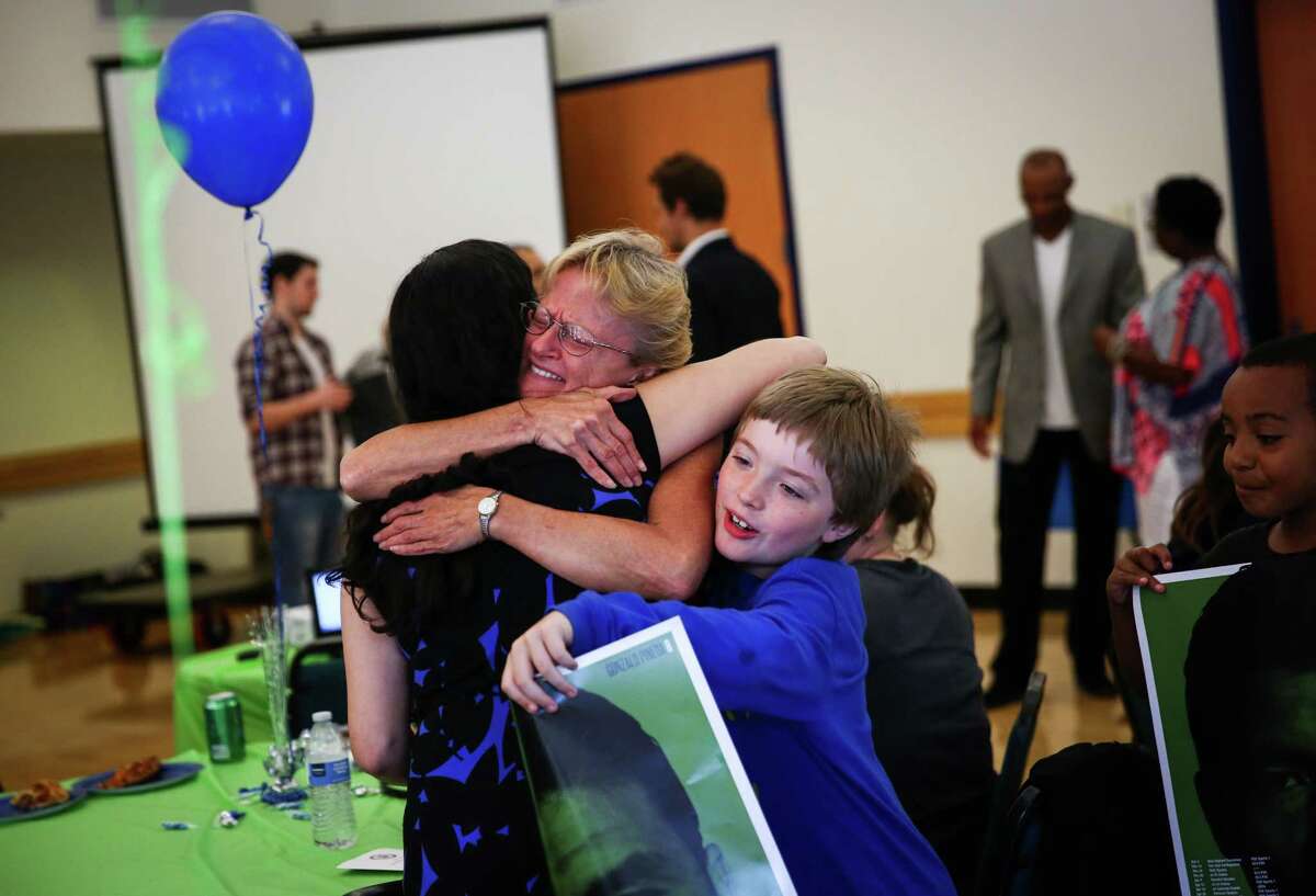 Sheryl Spencer hugs a staff member from the King County Prosecutors Office during an event honoring students that completed a King County Truancy Program. Spencer's grandson Lance Wegner, 9, participated in the program. Students that completed the program were honored by Prosecutor Dan Satterberg, former Sounders player Roger Levesque and former Seahawks player Paul Johns at the Tukwila Community Center on Friday, June 12, 2015.