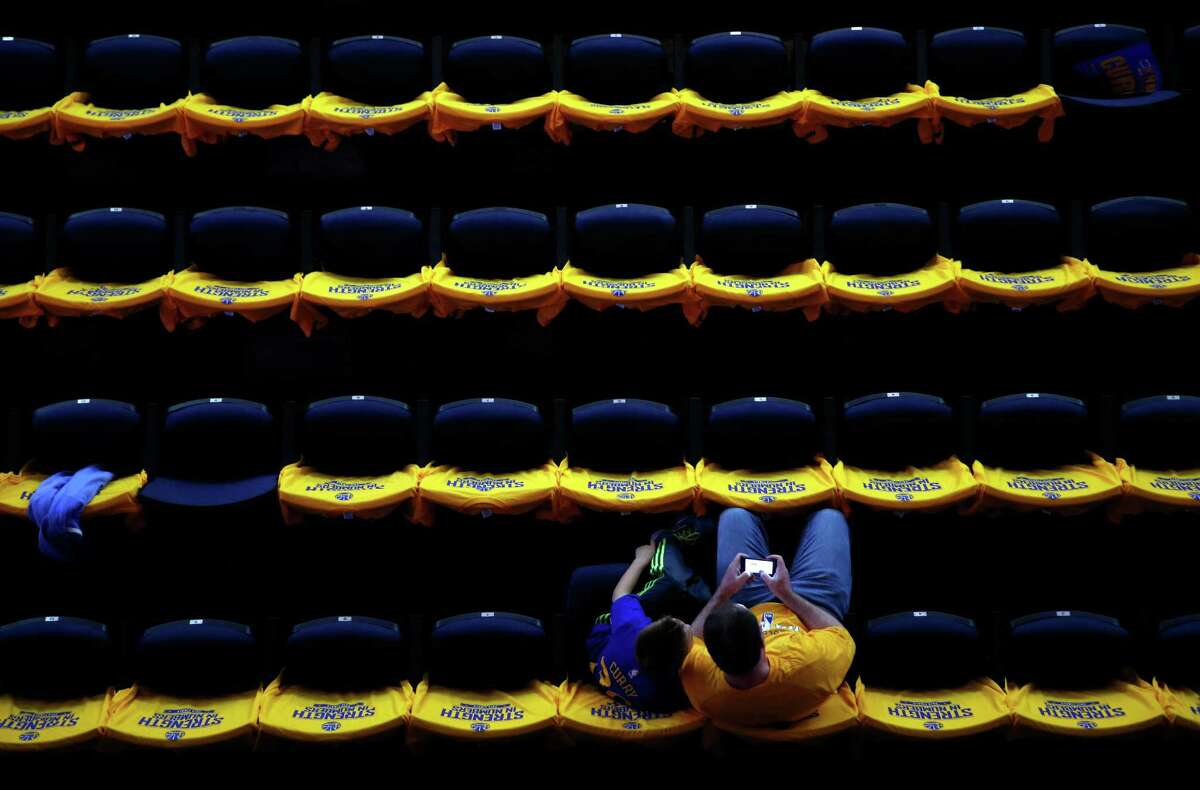 2015年6月14日，周日，加州奥克兰市甲骨文球馆，金州勇士队的球迷加拉格尔·杰夫和他9岁的儿子卢卡斯正在等待NBA总决赛第五场的开始。