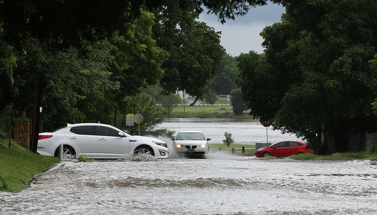 Cars maneuver along a flooded Lake Boulevard in the Monticello Park Historical District after thunderstorms rolled through San Antonio, Sunday, June 14, 2015. Chances for thunderstorms are expected to continue through most of the week.