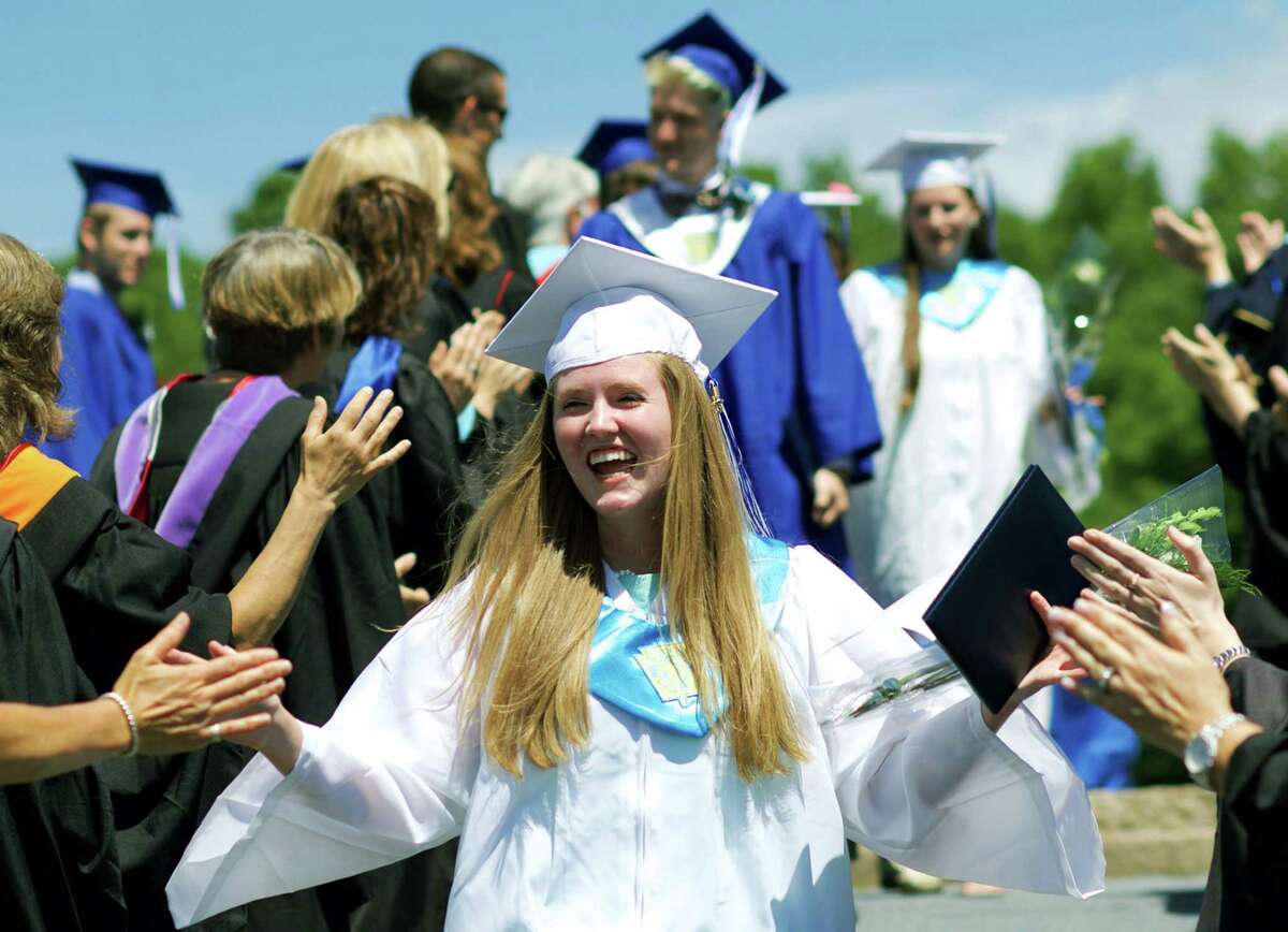 Class of 2015 president Rachel Crossley exchanges high-fives with faculty members as she leads the recessional following the commencement ceremony. Immediately following Rachel are valedictorian Sebastian Taylor and salutatorian Kelsey Johnson.