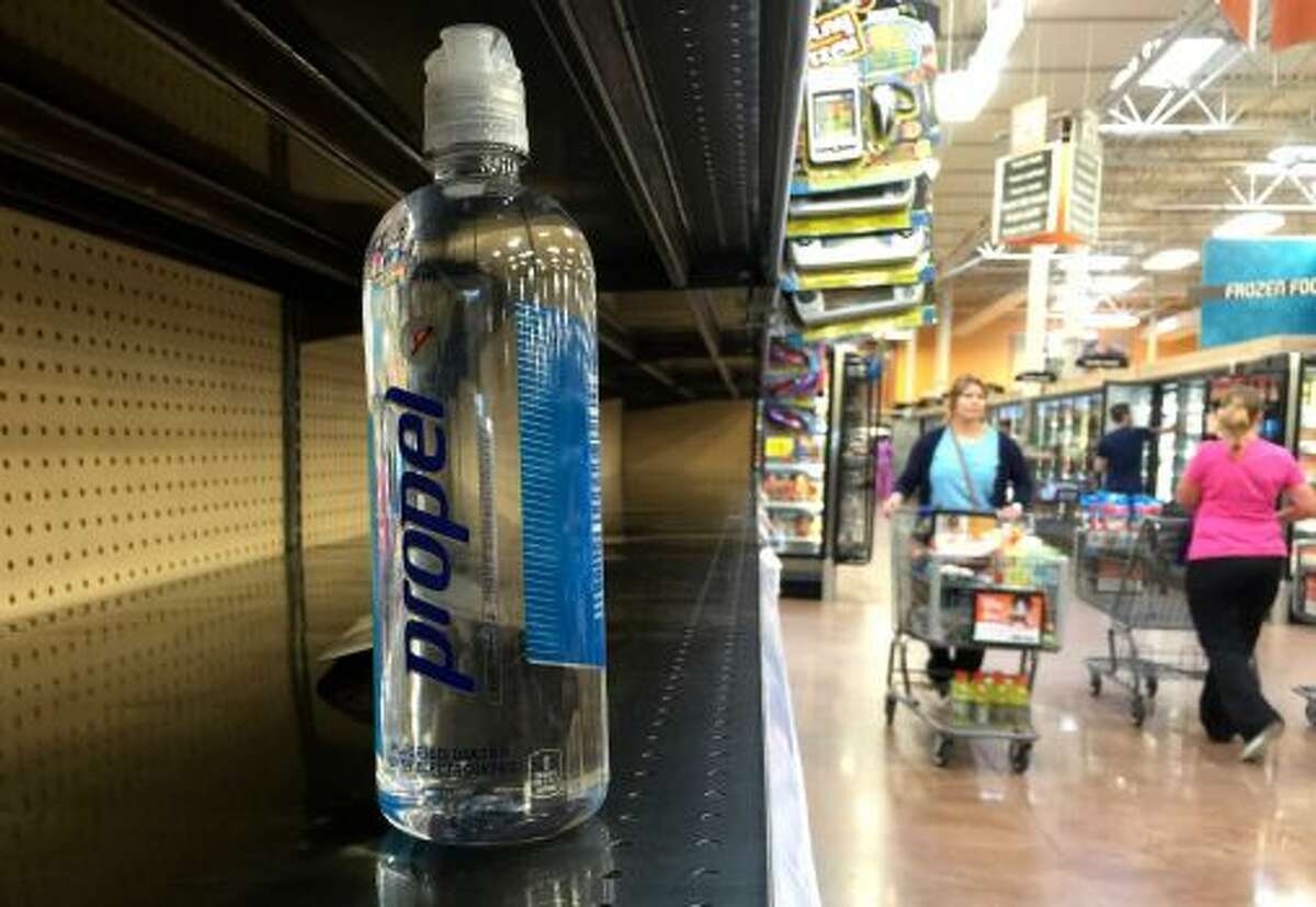 A bottle of water sits on a nearly empty shelf at a grocery store as residents around Houston quickly snatch up bottled water and other supplies on Monday. (June 16, 2015)