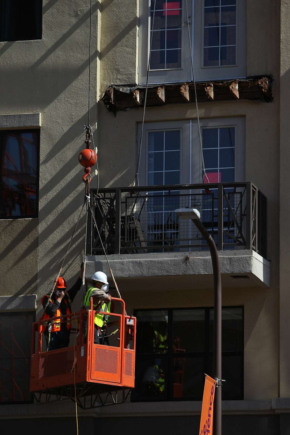 A balcony below the one that collapsed is worked on at 2020 Kittredge Street in Berkeley, California, on Tuesday, June 16, 2015. The collapse, which took place in the early hours of Tuesday, killed 6 and injured others.