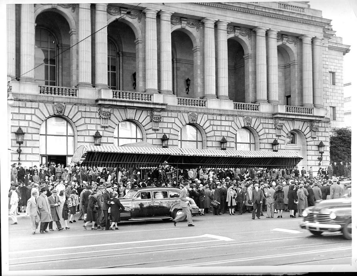 在旧金山歌剧院前的人行道上，代表们和观众擦着肩，在联合国会议开幕式结束后，他们列队离开大楼