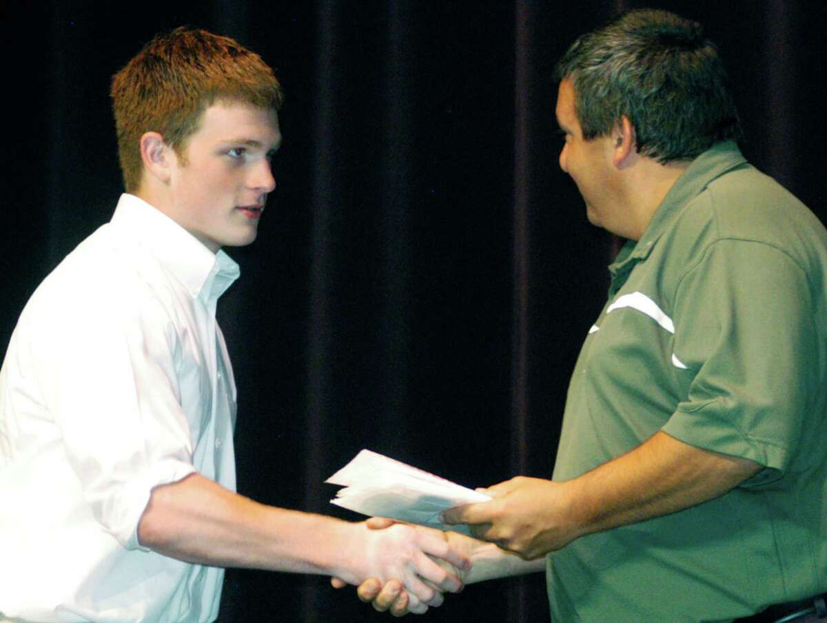Left, Green Wave boys’ lacrosse coach Greg LaCava, at right, congratulates John Phillips during the awards ceremony.