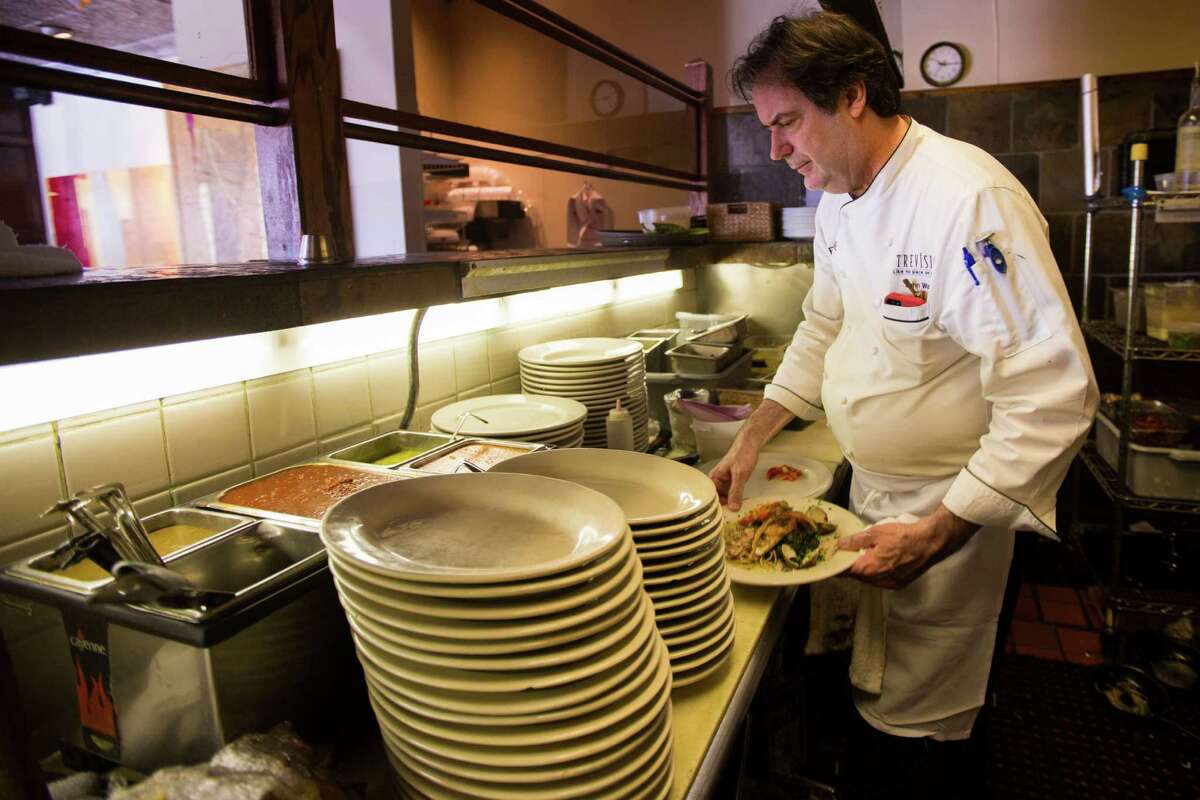John Watt is the executive chef and proprietor of Prego, a neighborhood Italian restaurant, prepares swordfish with clams, roasted garlic and roasted peppers. Wednesday, June 10, 2015, in Houston.
