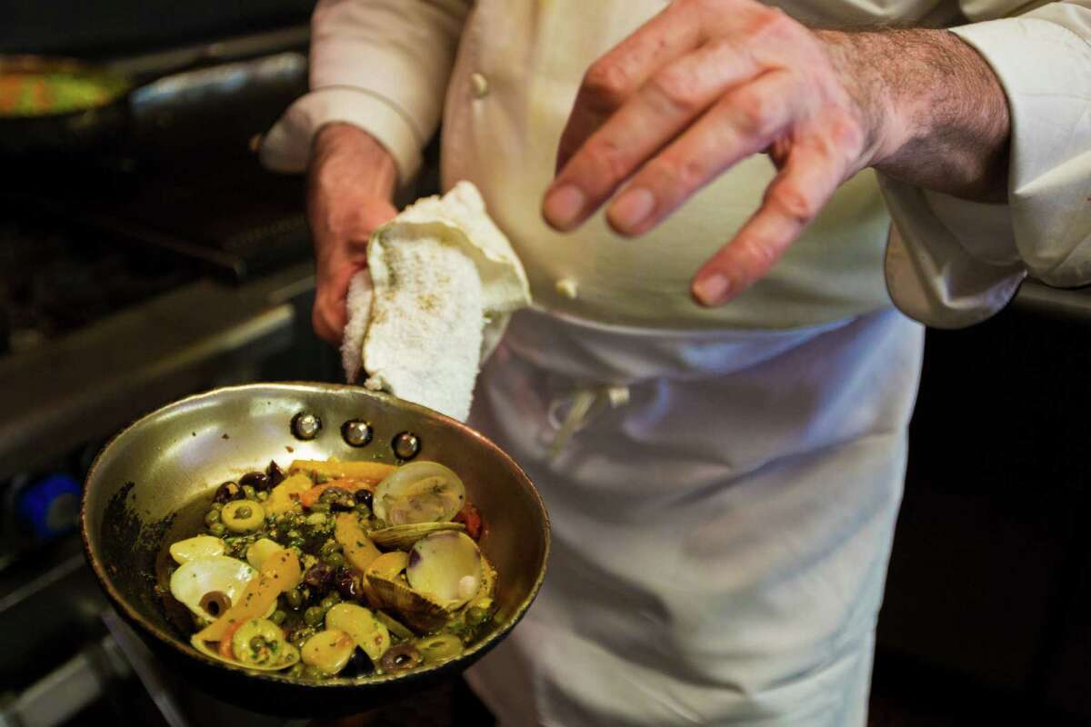 John Watt is the executive chef and proprietor of Prego, a neighborhood Italian restaurant, prepares clams to go with swordfish, roasted garlic and roasted peppers. Wednesday, June 10, 2015, in Houston.