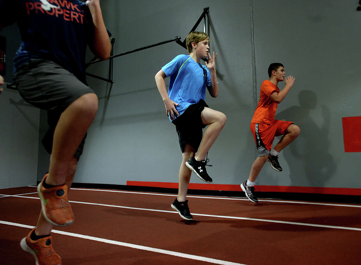 Cody Caldwell, 12, (left) and Griffin McClelland, 10, high step their way down the track during strength training at the Parisi Speed school of Beaumont. Instructor Brittney O'Pry is helping young athletes of all ages and abilities the opportunity to increase their ability through a combination of strength and speed training sessions. Photo taken Thursday, June 18, 2015 Kim Brent/The Enterprise