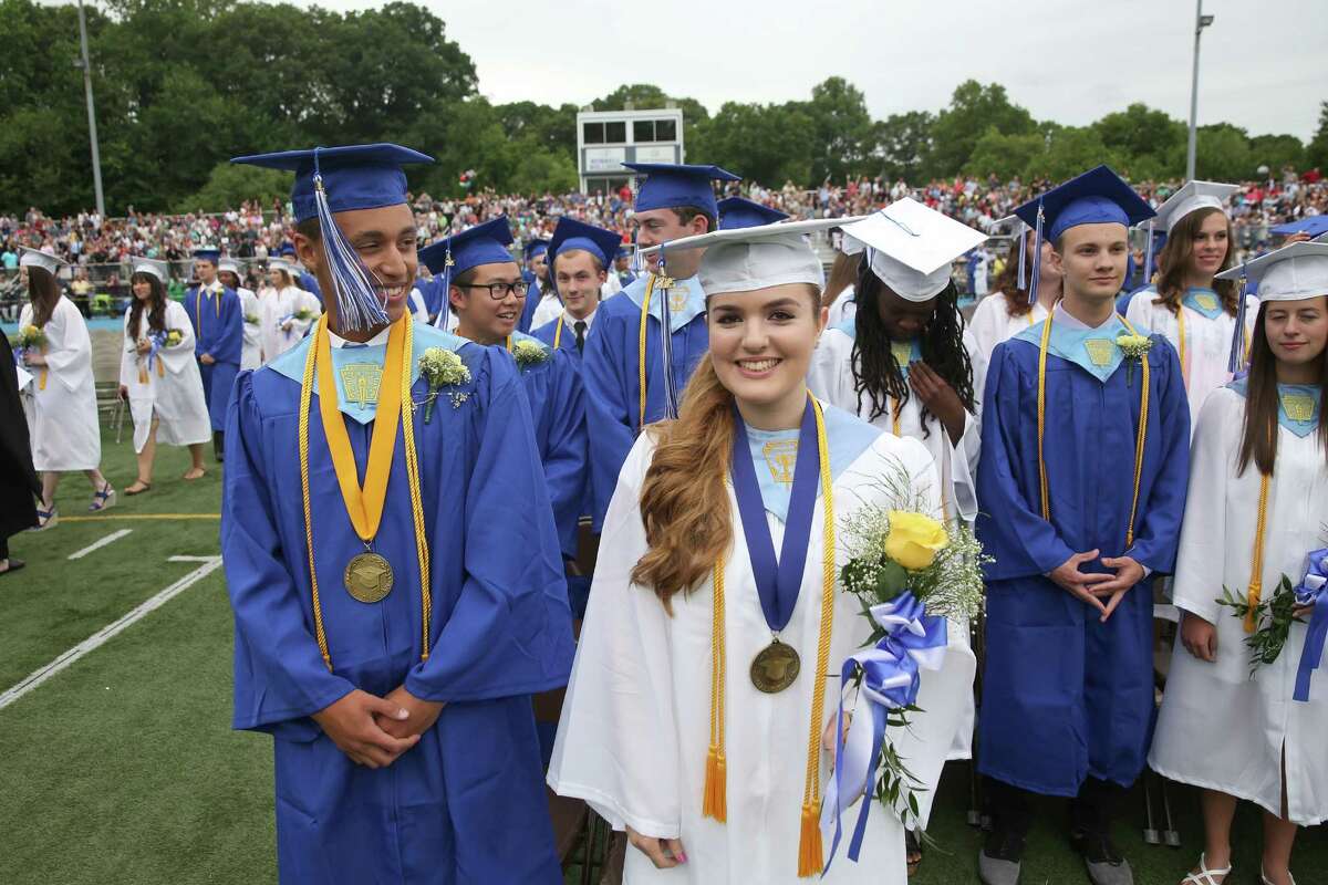 Bunnell High School Salutatorian Tyler Stefan LeComer and Valedictorian Julian Marie Sharp stand at attention during opening of the commencement ceremony at the school in Stratford, Conn. on June 18, 2015. LeComer will attend Harvard and Sharp will attend Juliard in the fall.